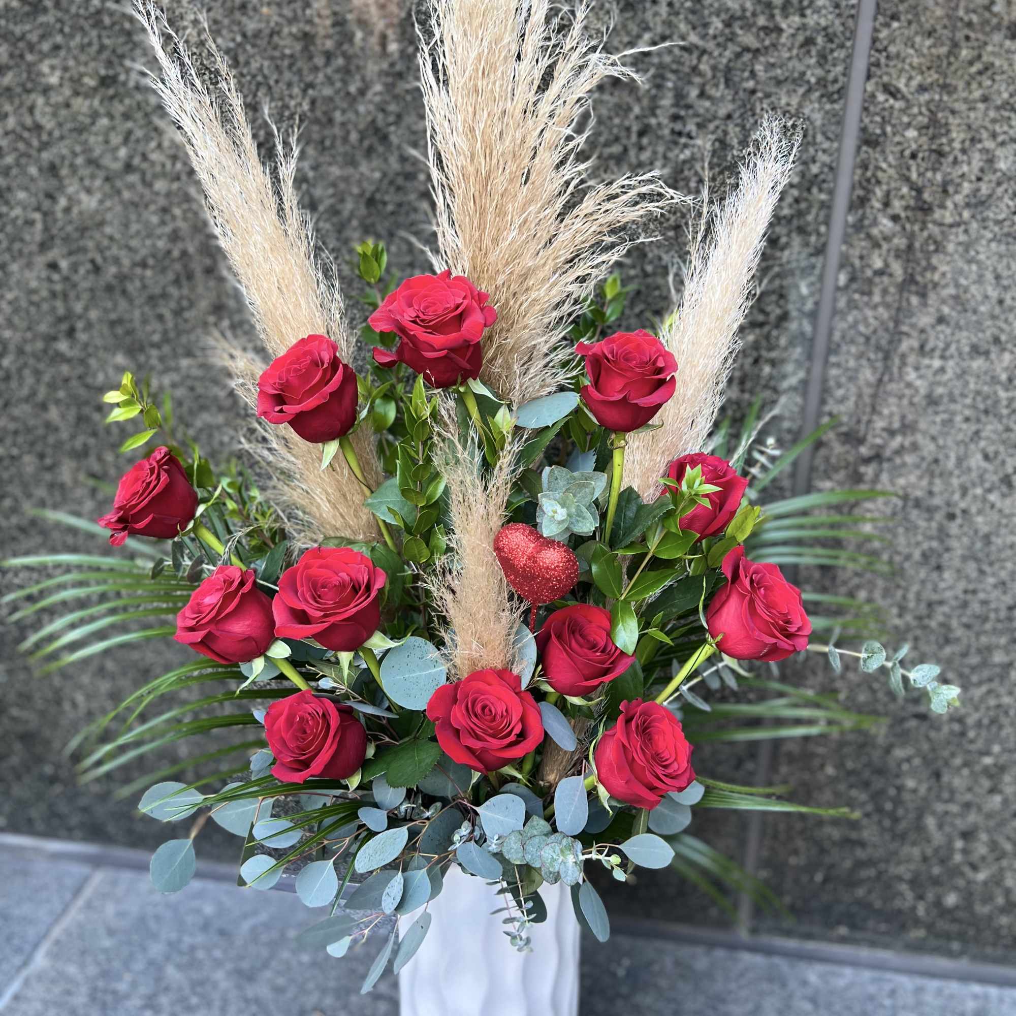 Tall bouquet of red roses with pampas grass in a white vase, photo 2 of 5
