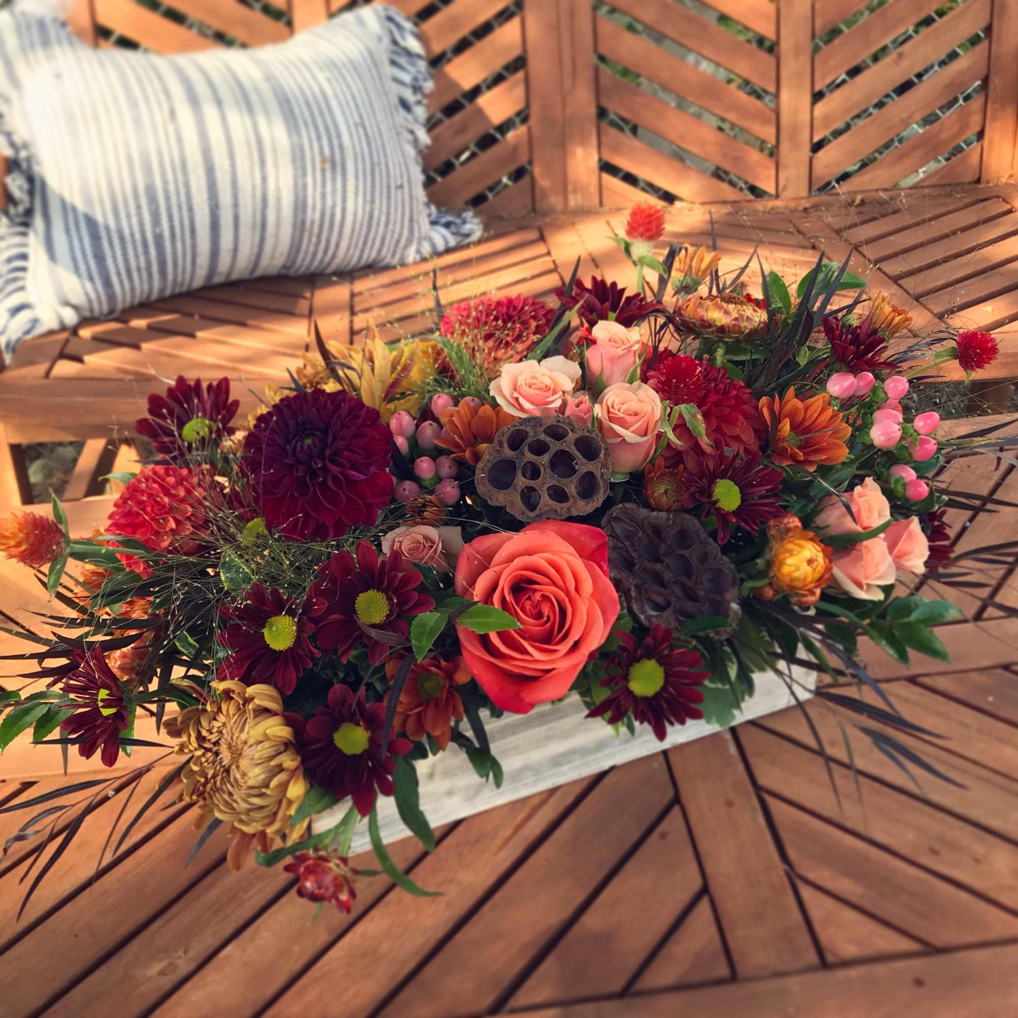 A lush centerpiece full of berries, lotus pods, seasonal foliage and fresh, photo 3 of 3