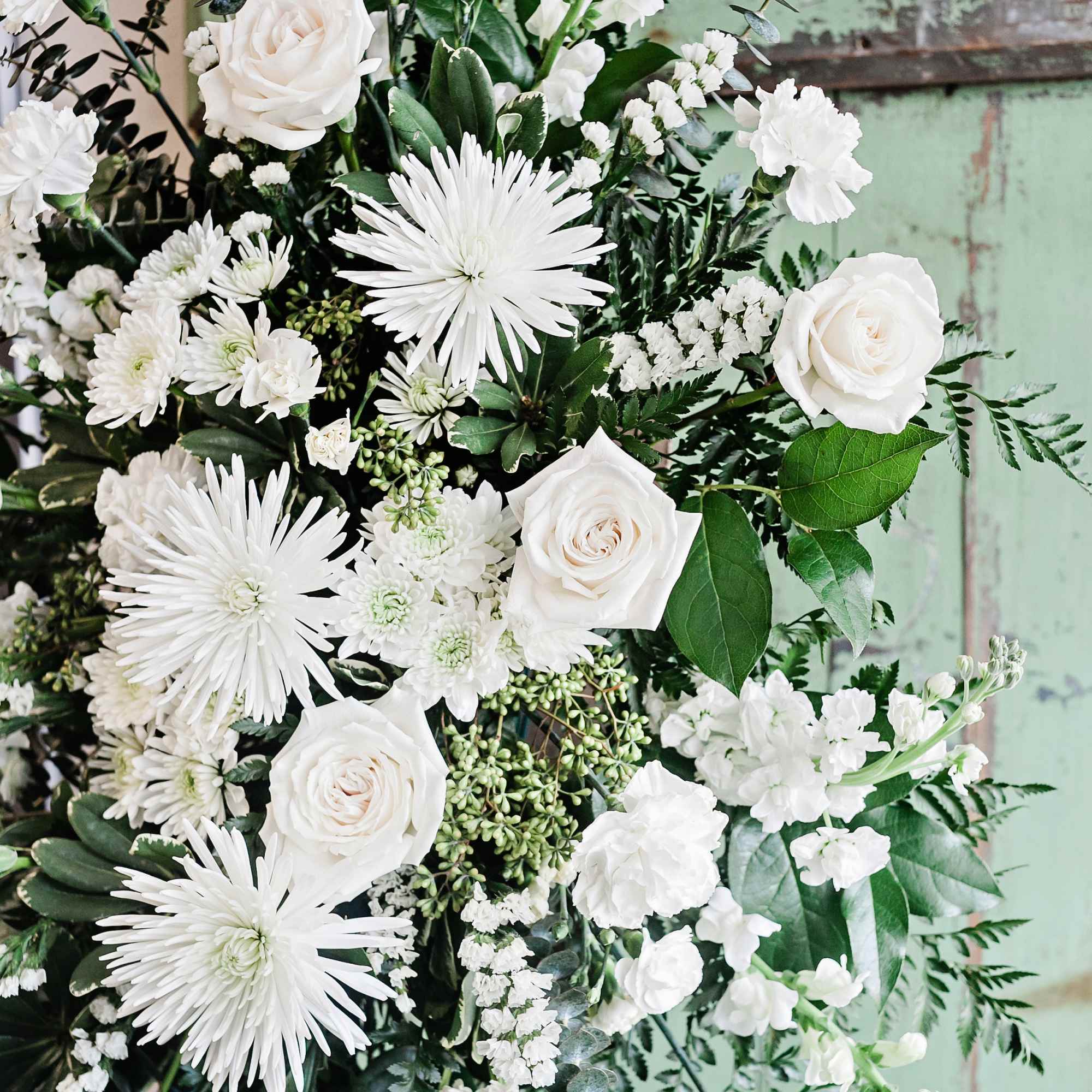 White roses and chrysanthemums arranged with greenery