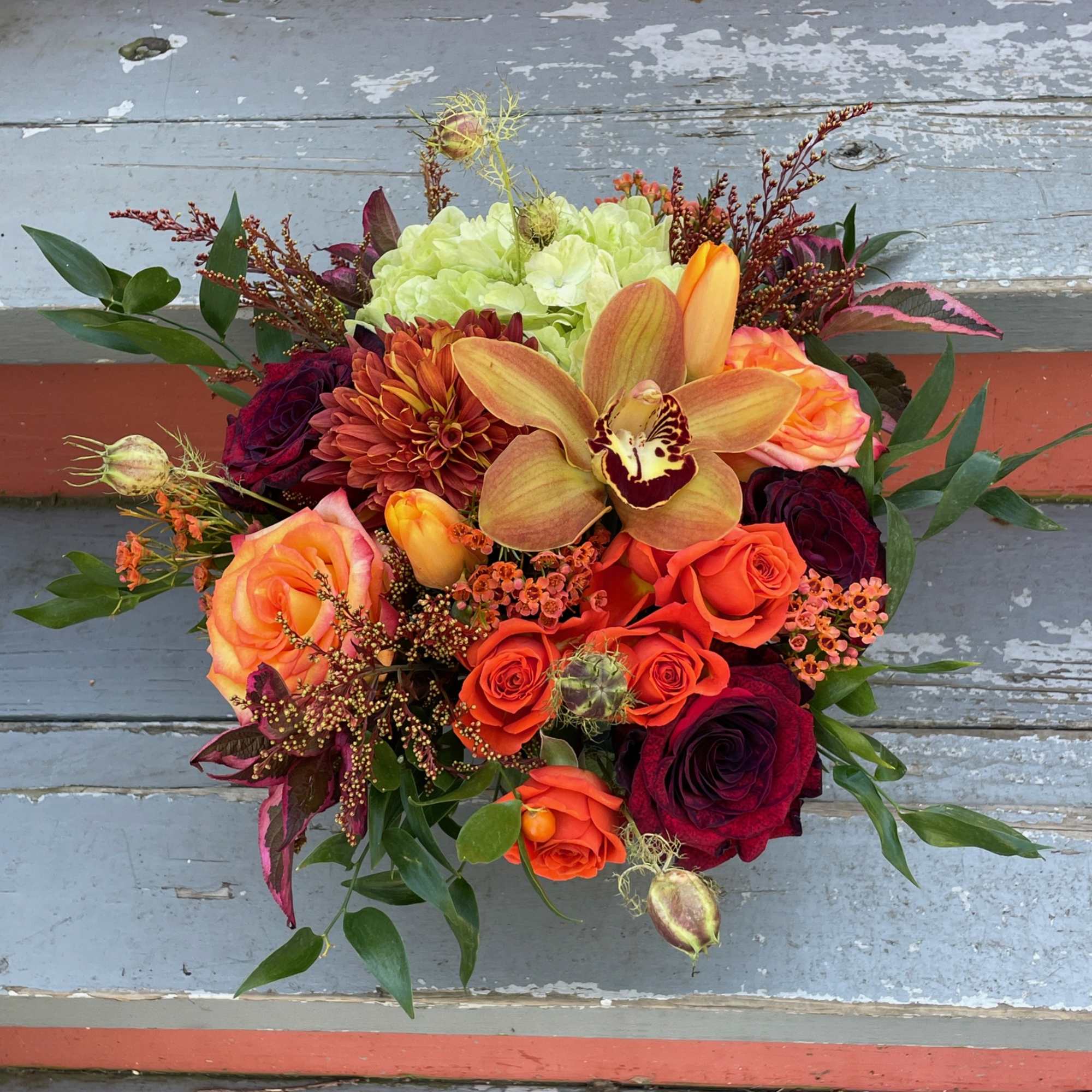Mixed bouquet with roses, an orchid, and a green hydrangea bloom