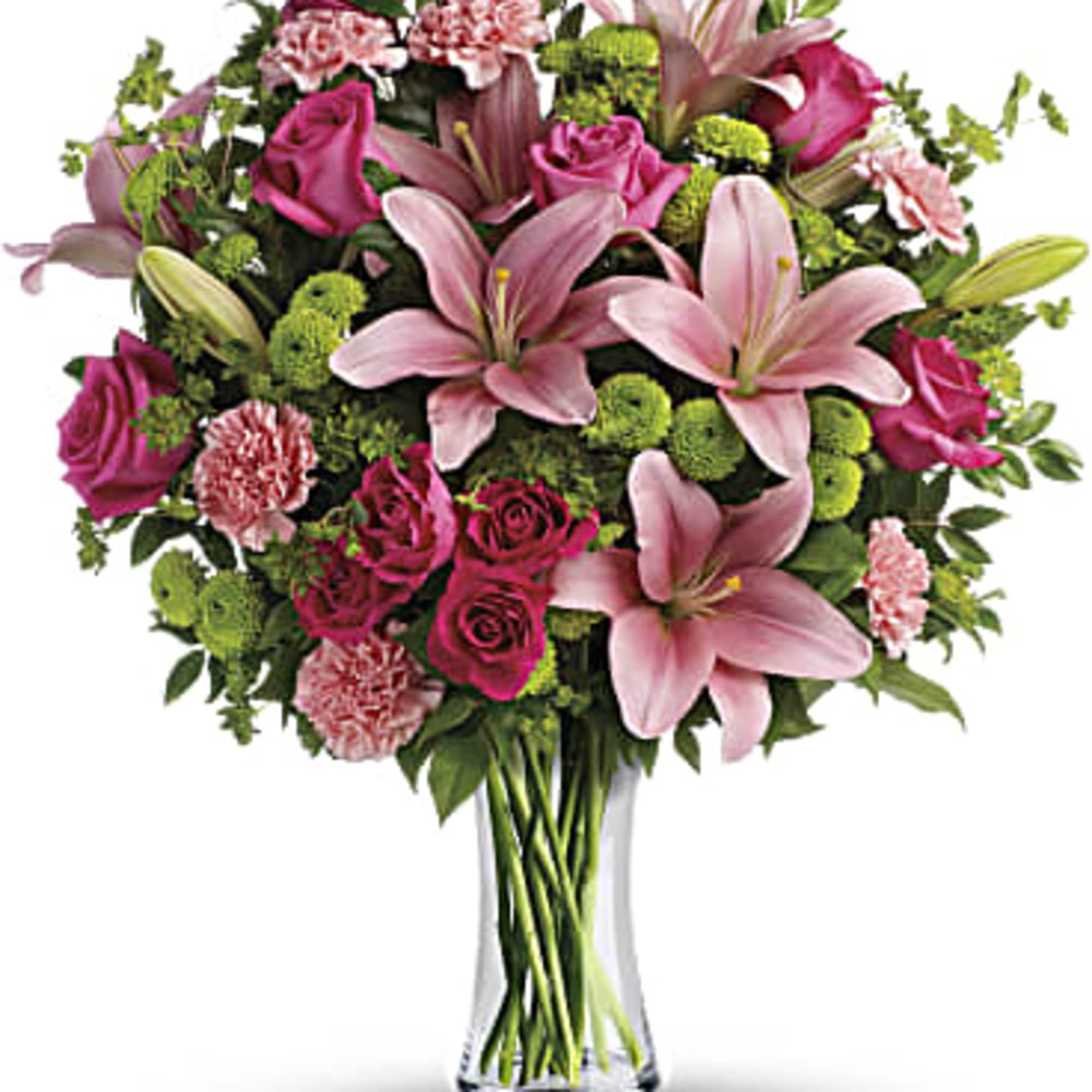Pink lilies, roses, and carnations in a clear glass vase
