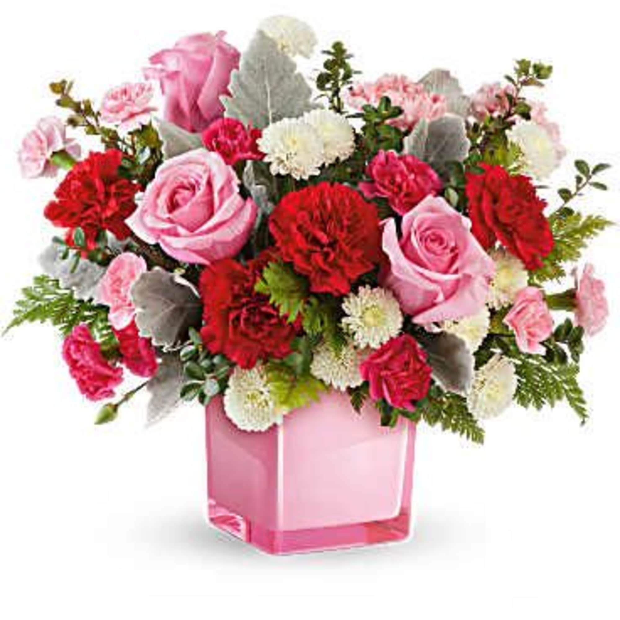 Pink and red flower arrangement in a pink glass vase