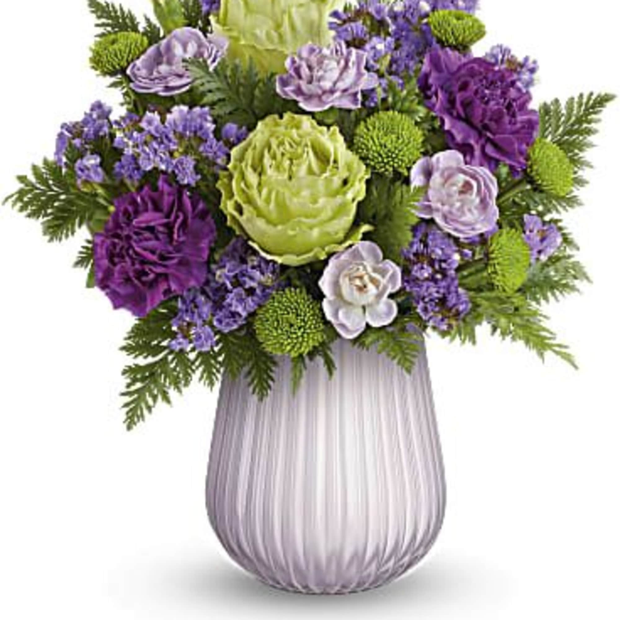 Purple and green floral arrangement in a ribbed glass vase