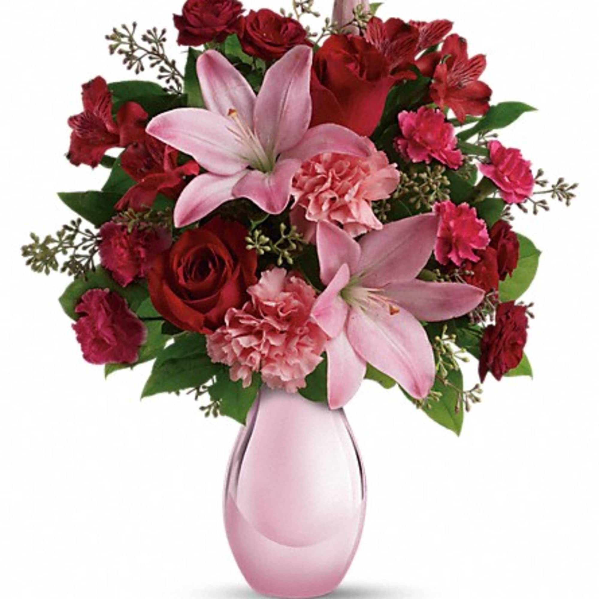 Pink lilies and red roses arranged in a pink glass vase