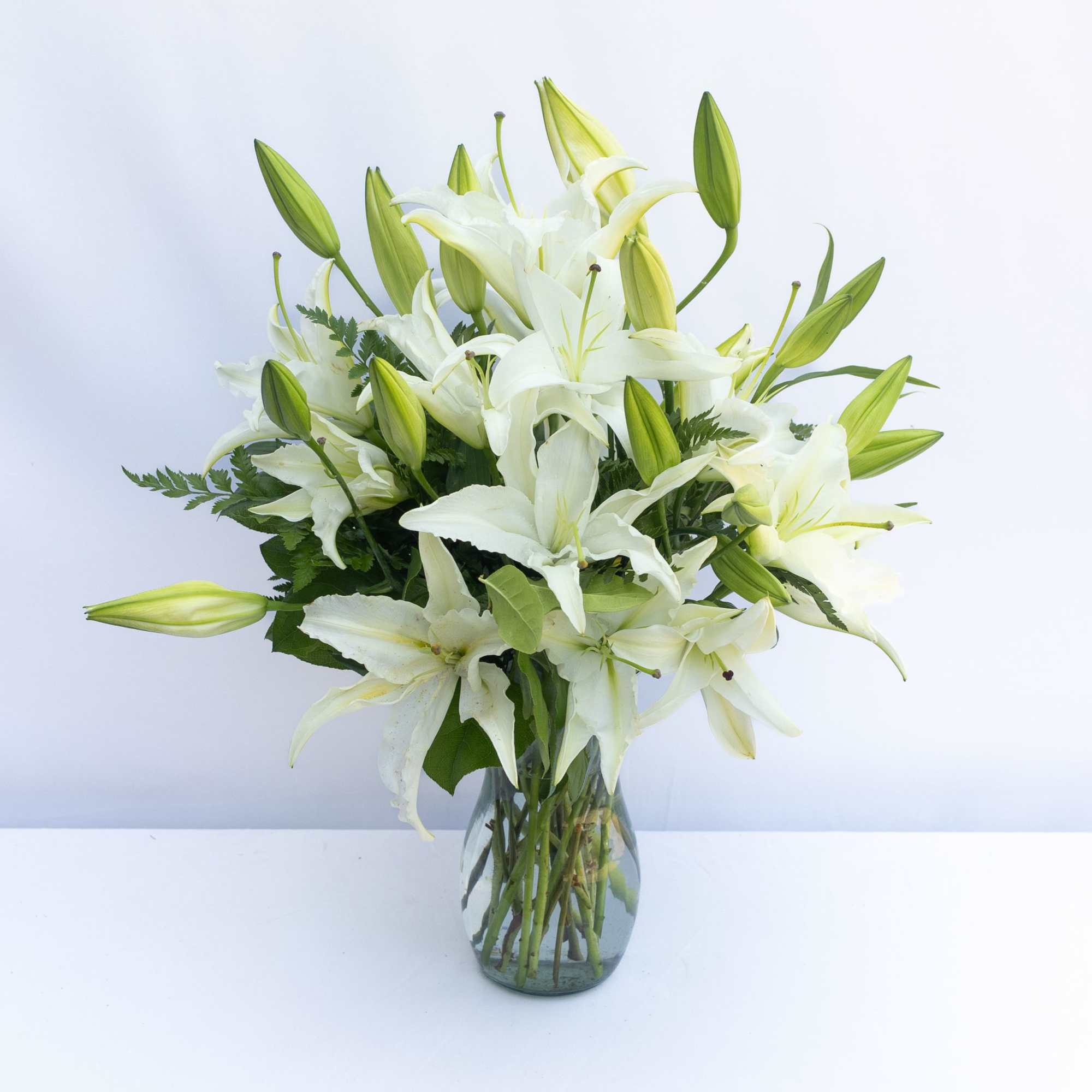 White lilies arranged in a clear glass vase
