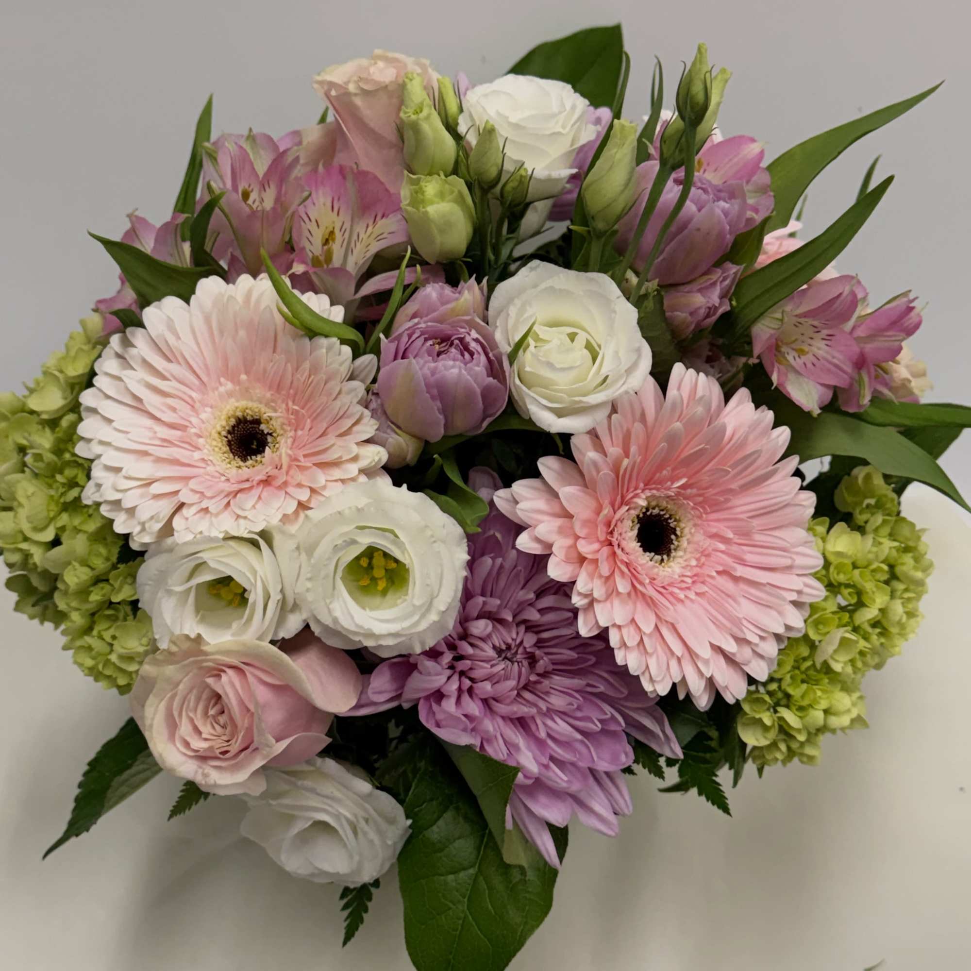 A lovely combination of pastels arranged in a compact pink gerberas, roses, photo 2 of 2