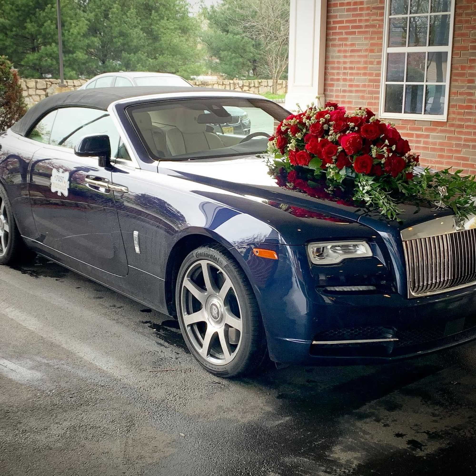 Red rose arrangement on the hood of a blue Rolls-Royce convertible