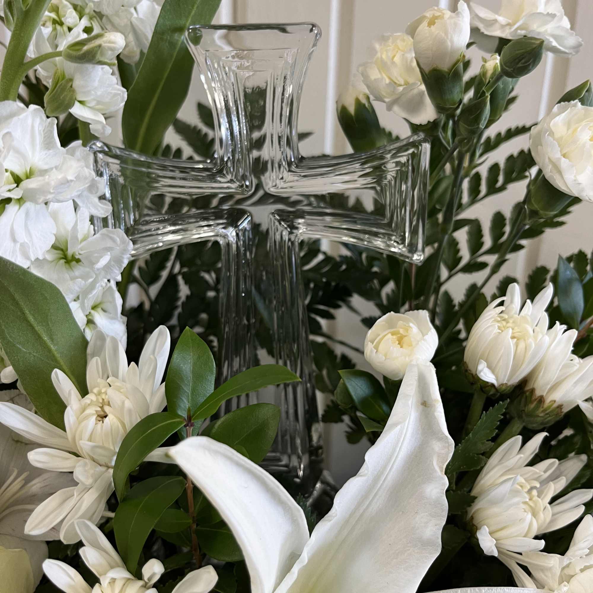 White floral arrangement with a glass cross centerpiece