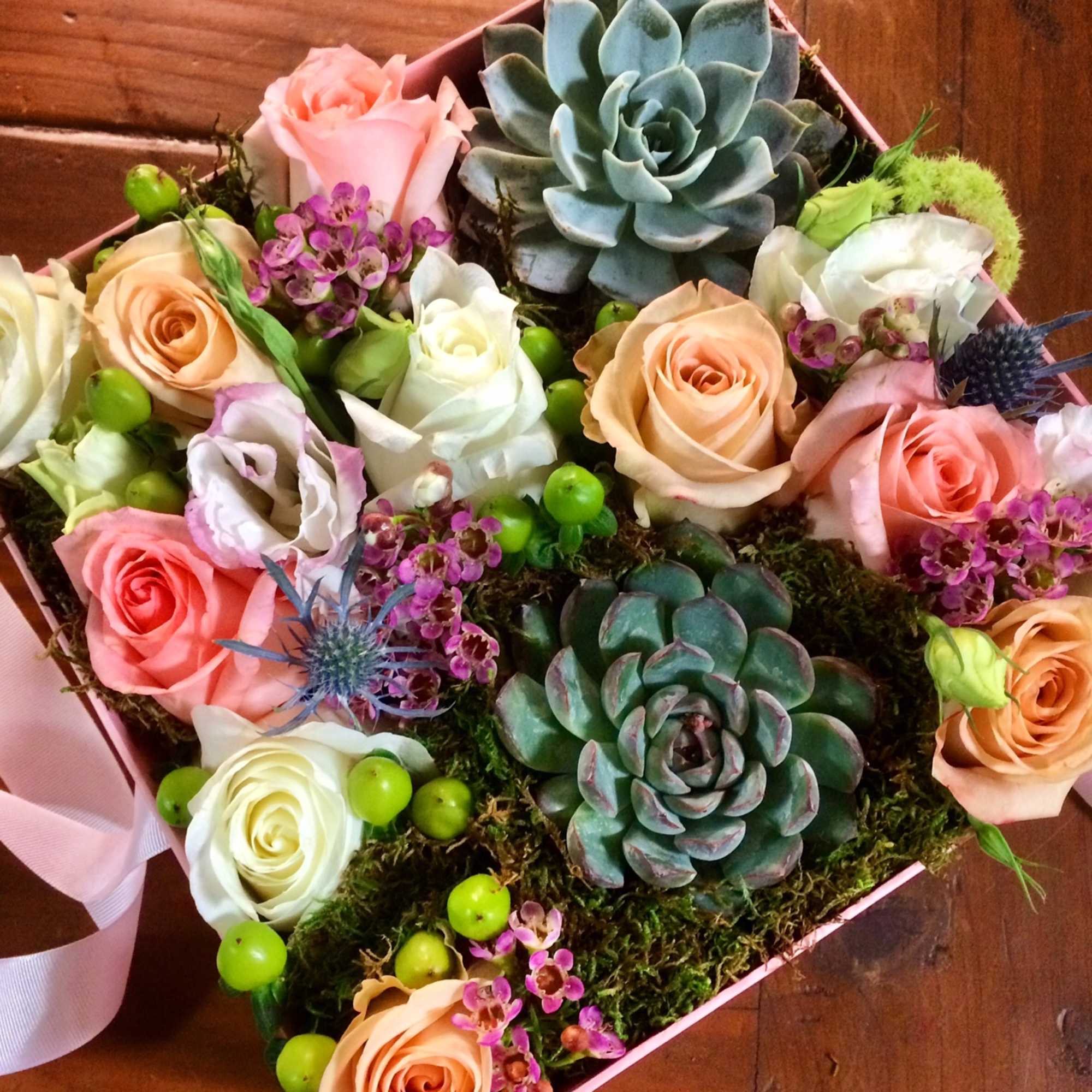 Heart-shaped box with roses, succulents, and small purple flowers