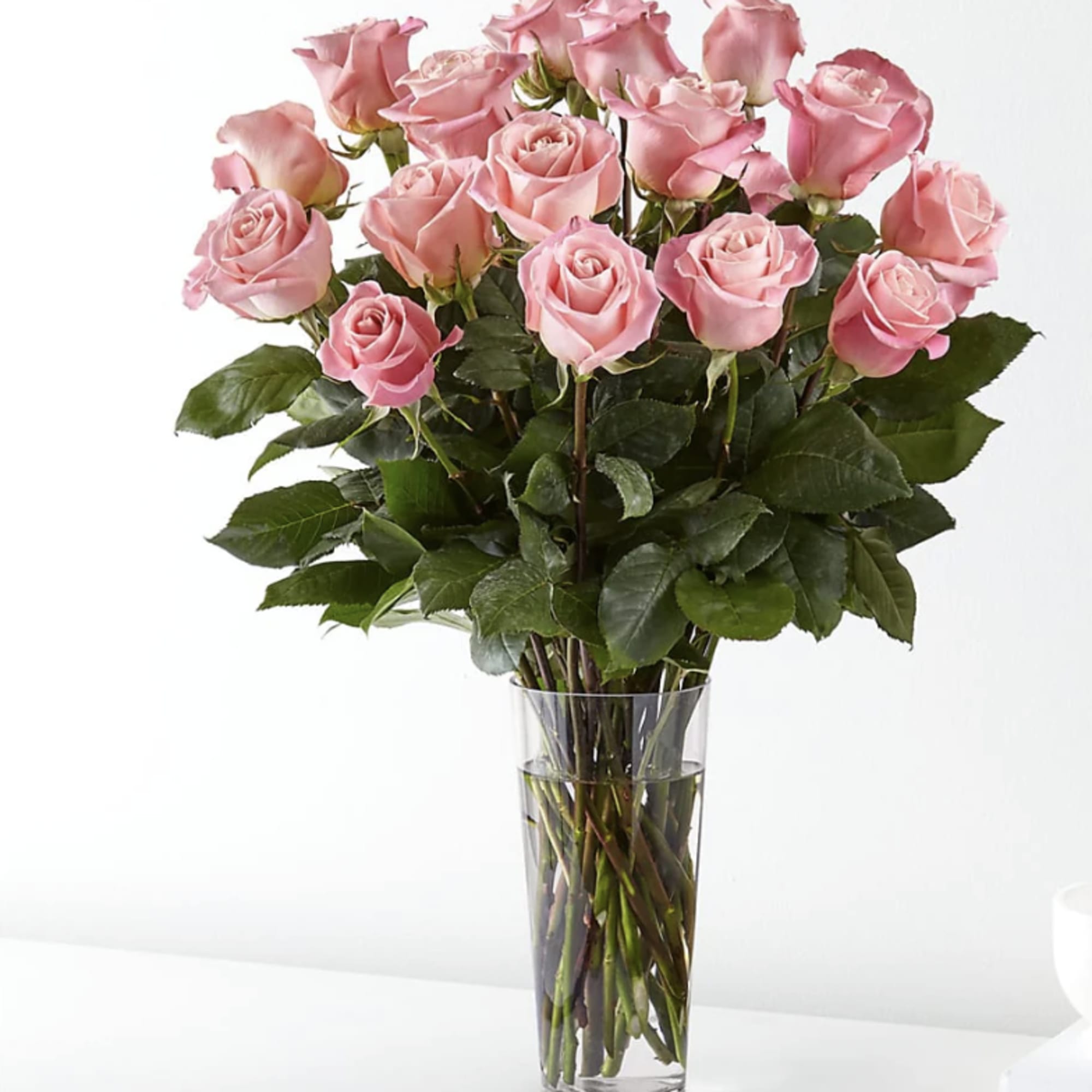 Pink roses arranged in a clear glass vase