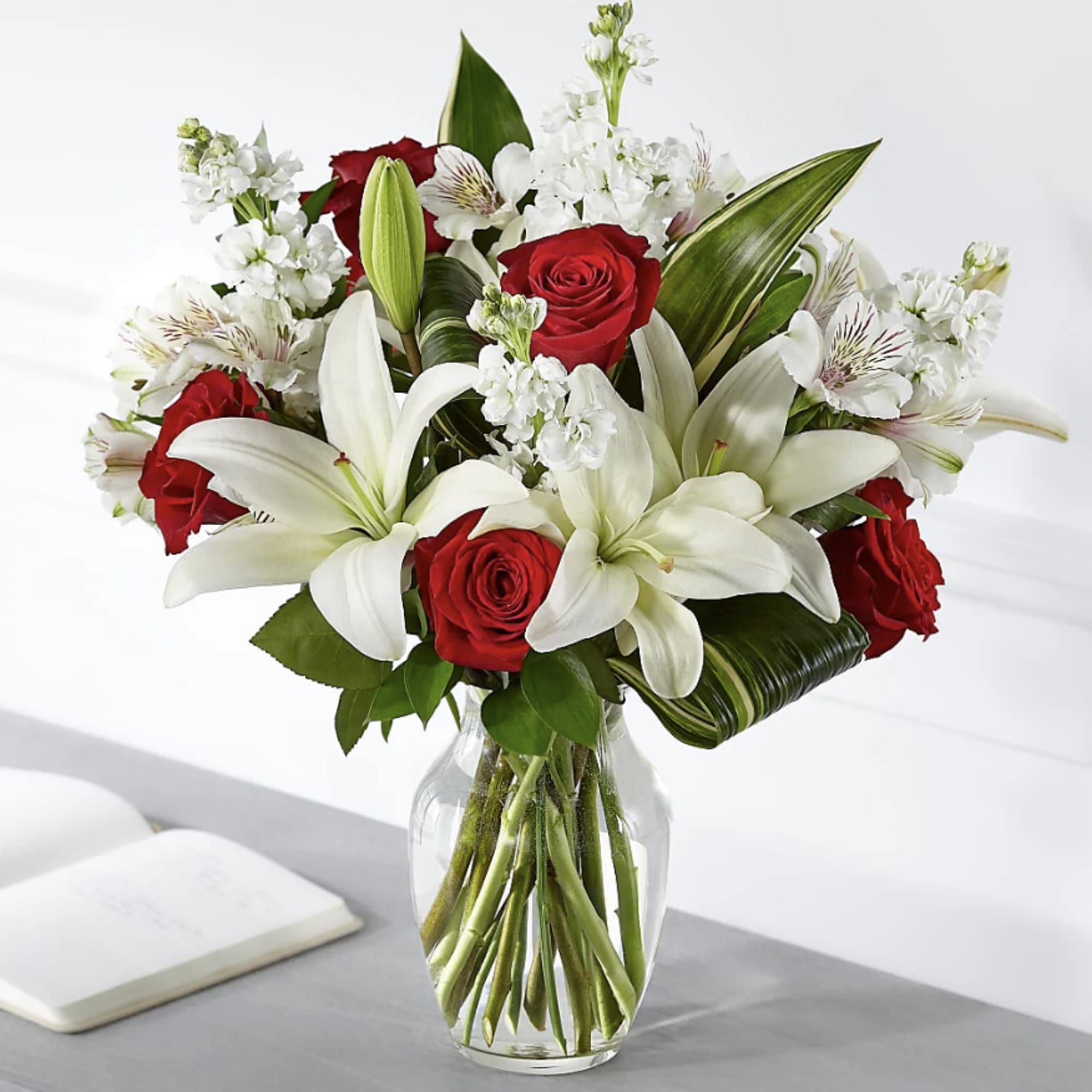 Red roses and white lilies in a clear glass vase