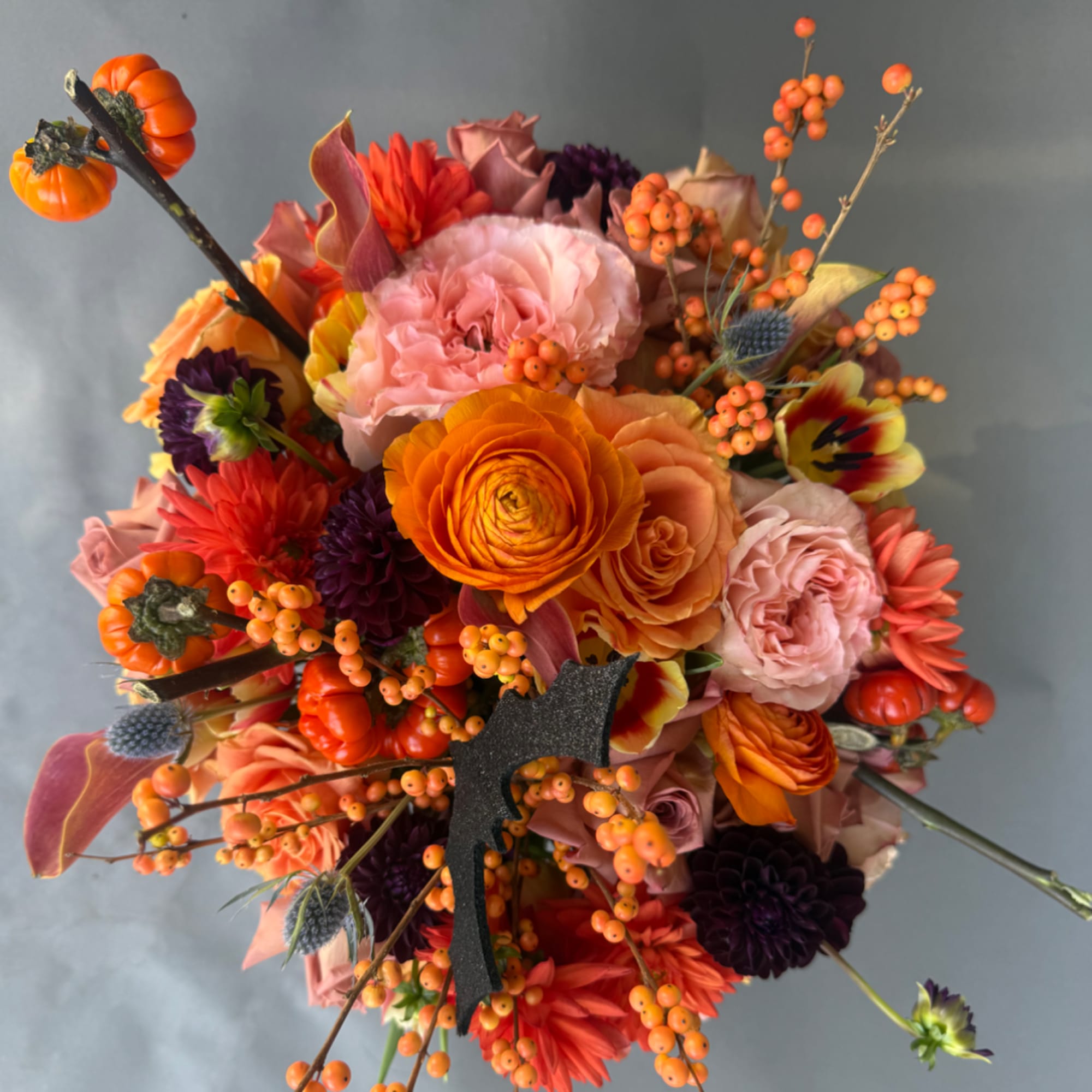 Autumn bouquet with orange, pink, and purple flowers and berries