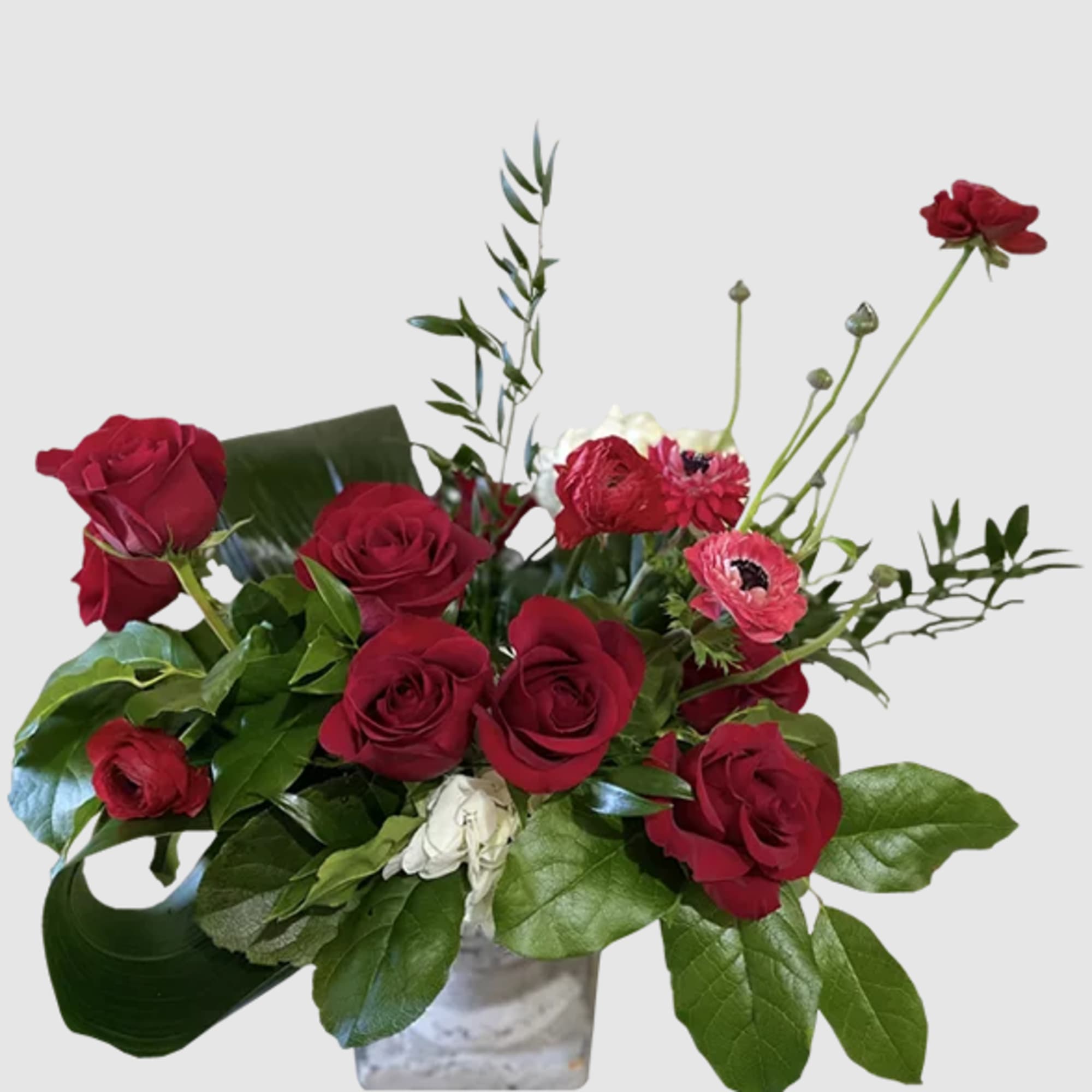 Red roses and pink gerbera daisies in a square vase