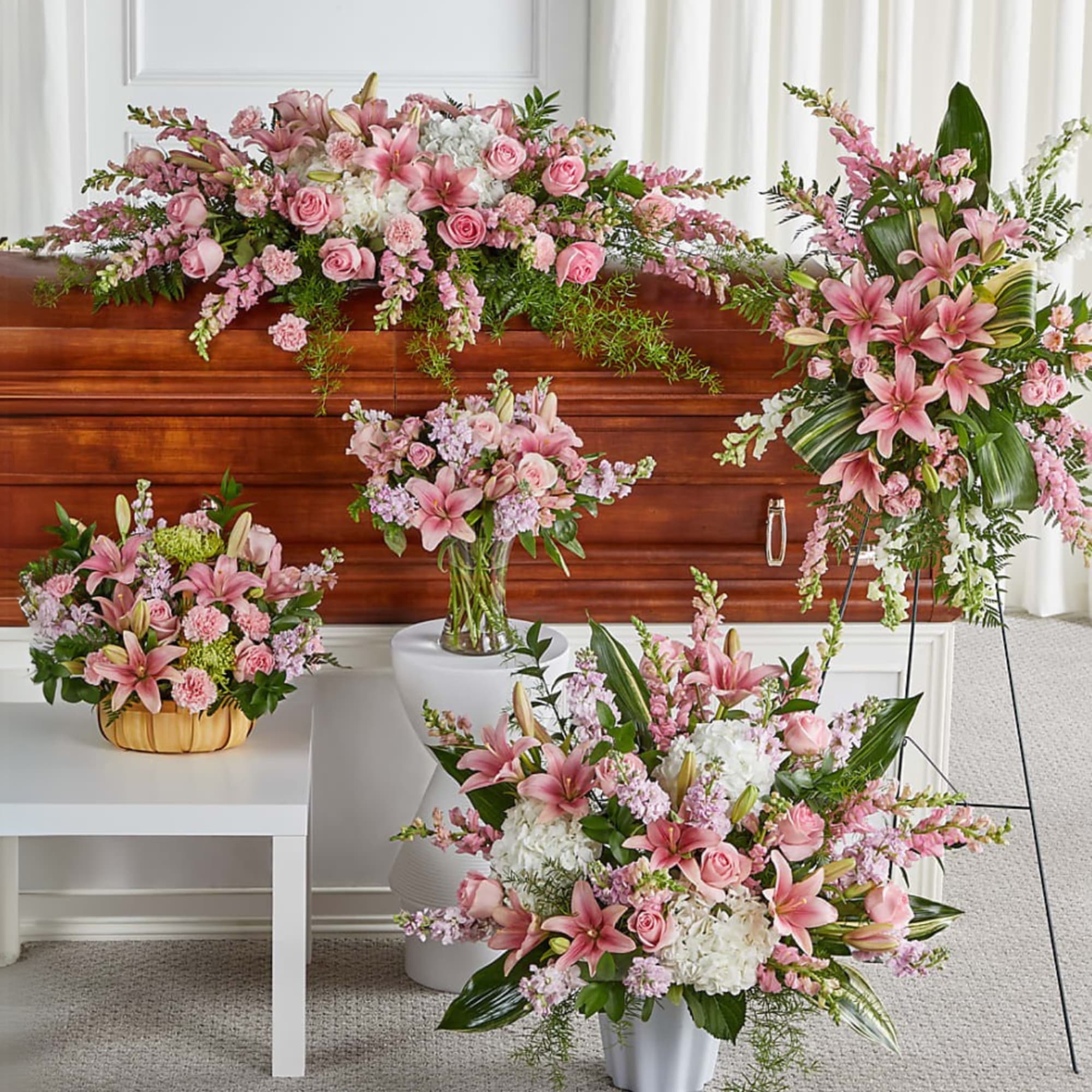 Pink and white funeral flowers arranged around a casket