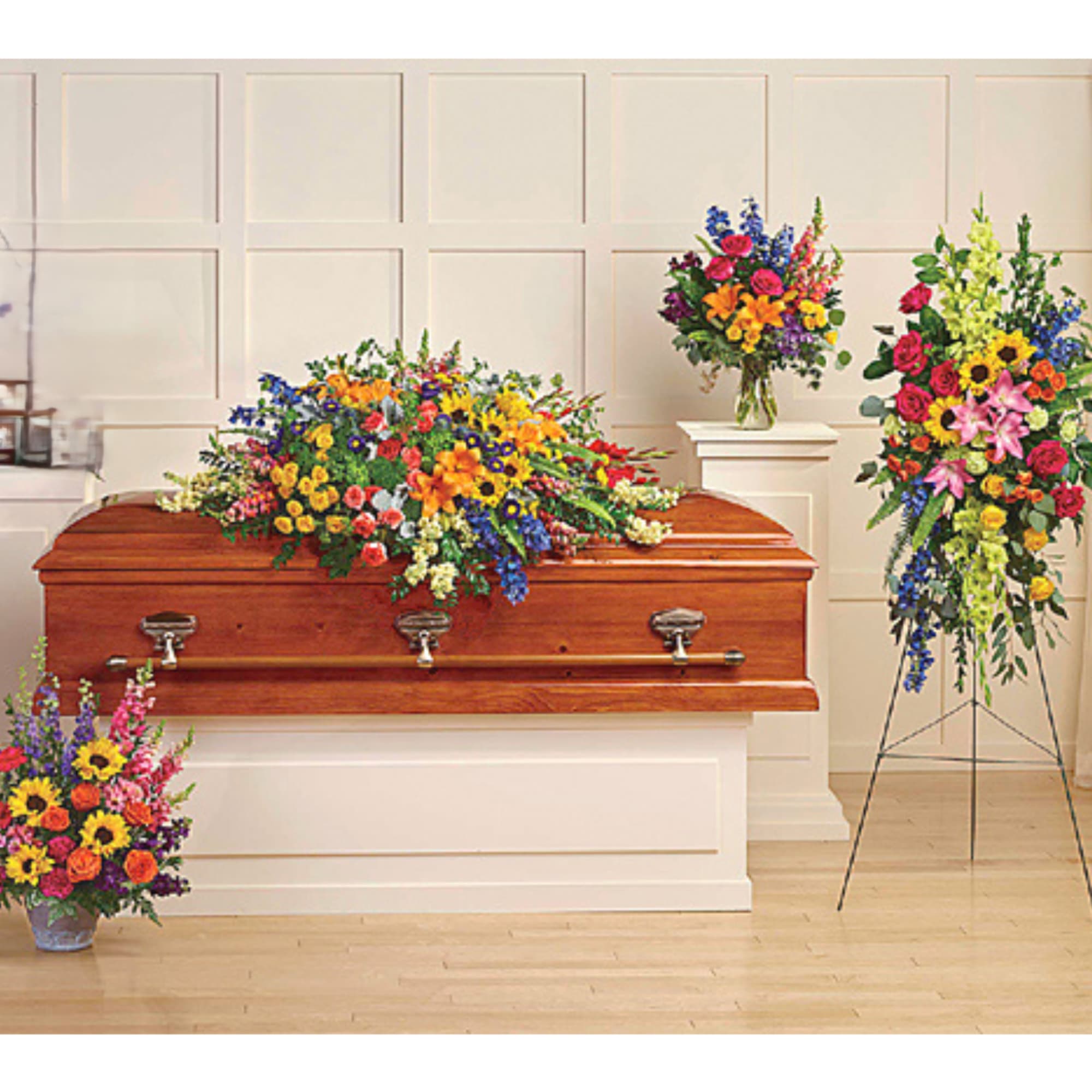 Colorful funeral casket spray with matching standing arrangements