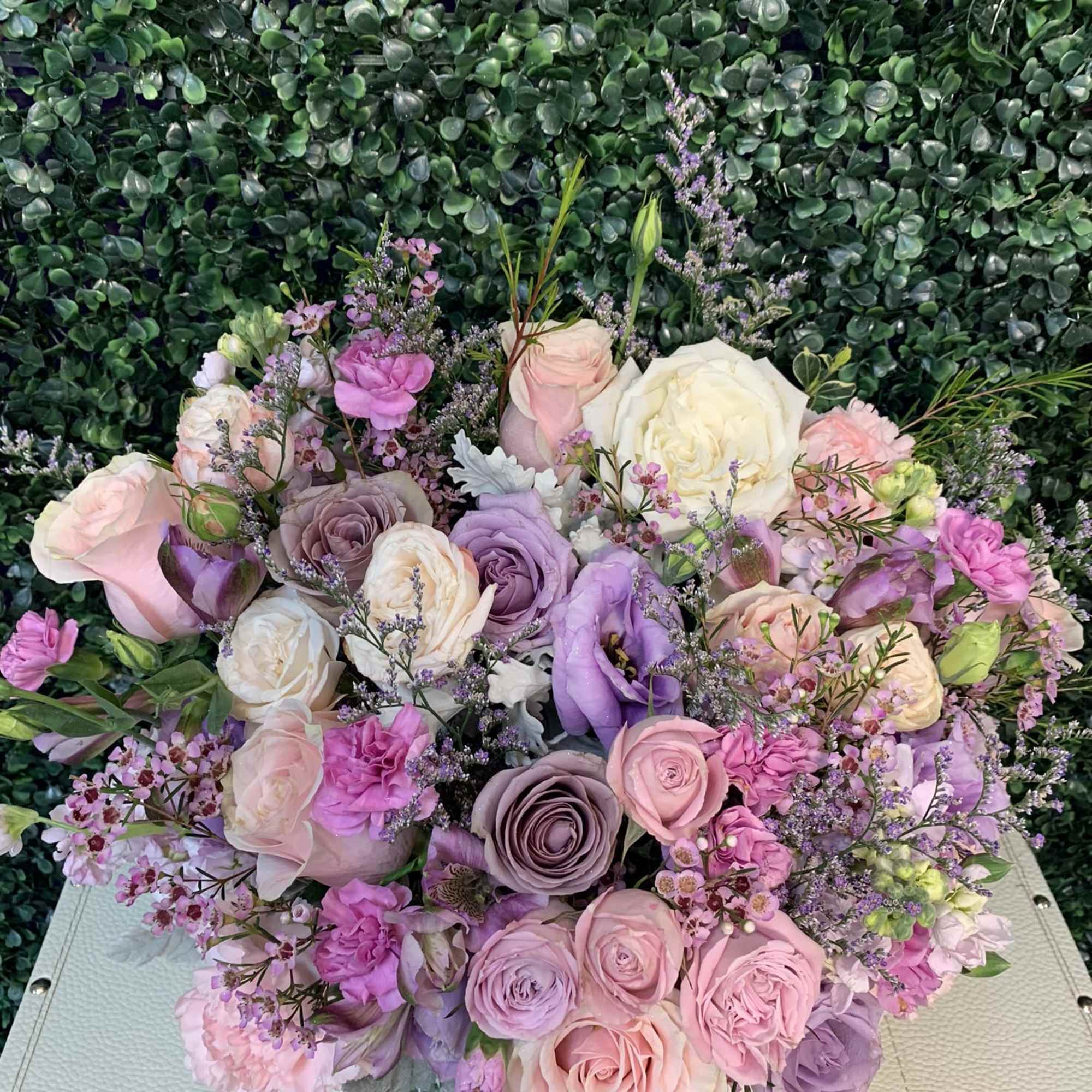 Pastel bouquet of roses and lisianthus with small purple filler flowers