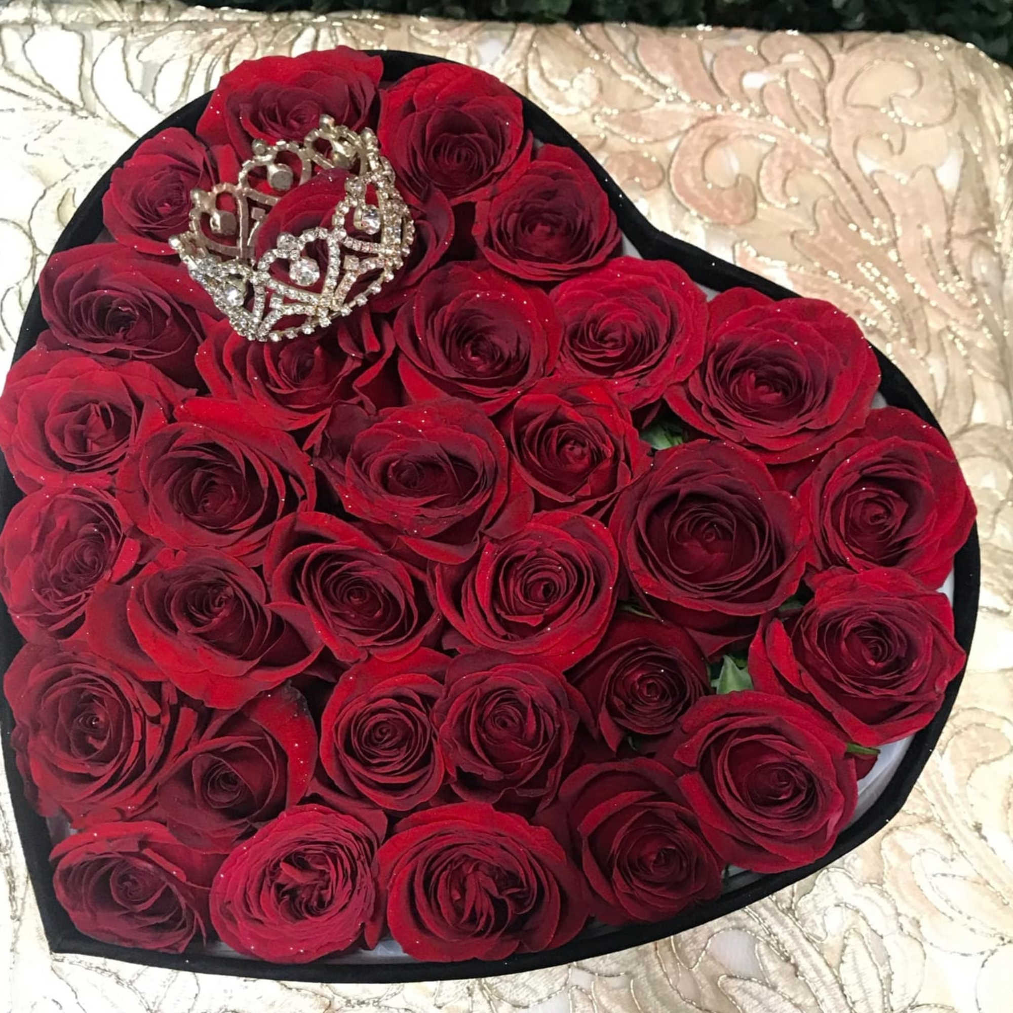 Heart-shaped box of red roses with a jeweled crown topper