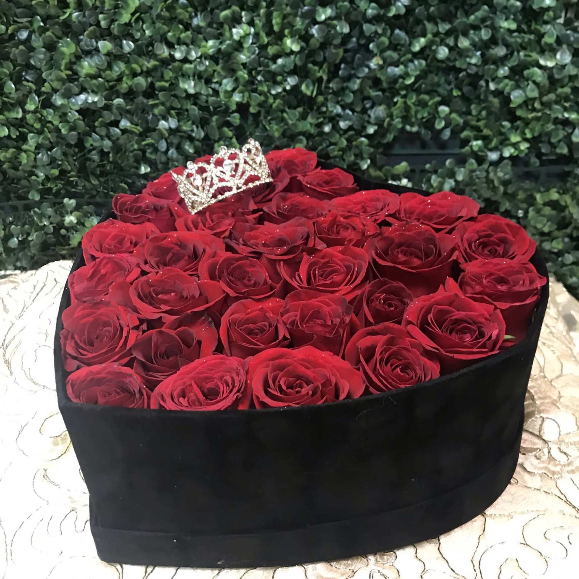Heart-shaped box of red roses with a small jeweled crown