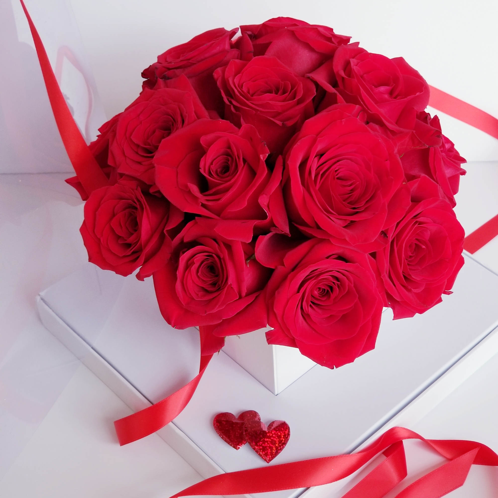 Bouquet of red roses in a white box with red ribbon