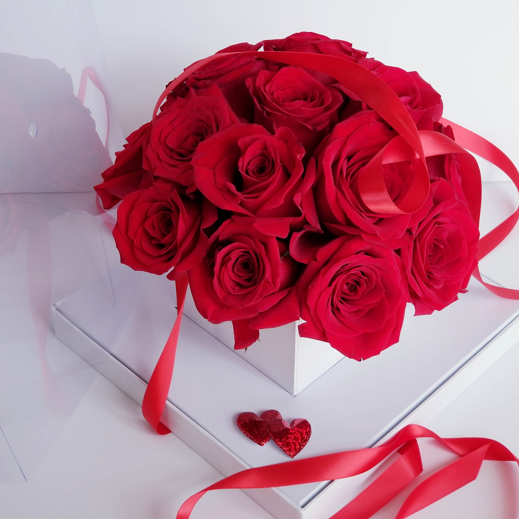 Bouquet of red roses with red ribbon in a white box