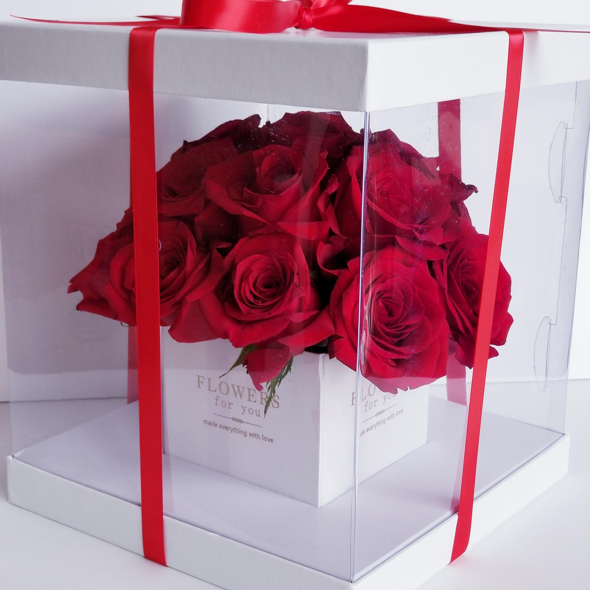 Red roses in a clear gift box tied with a red ribbon