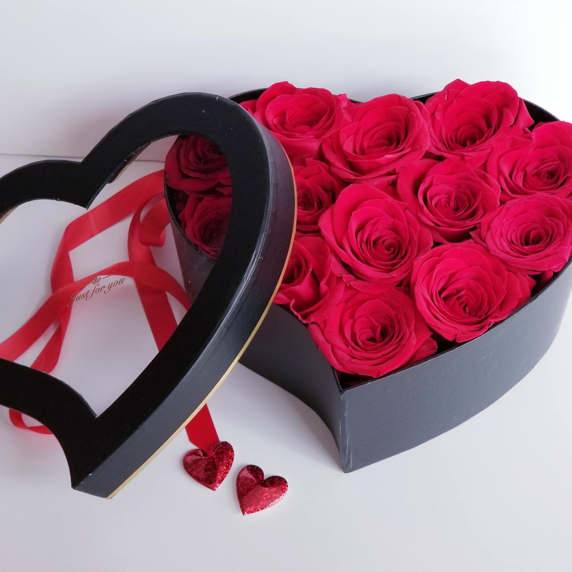 Heart-shaped box of hot pink roses with a ribbon and heart decorations