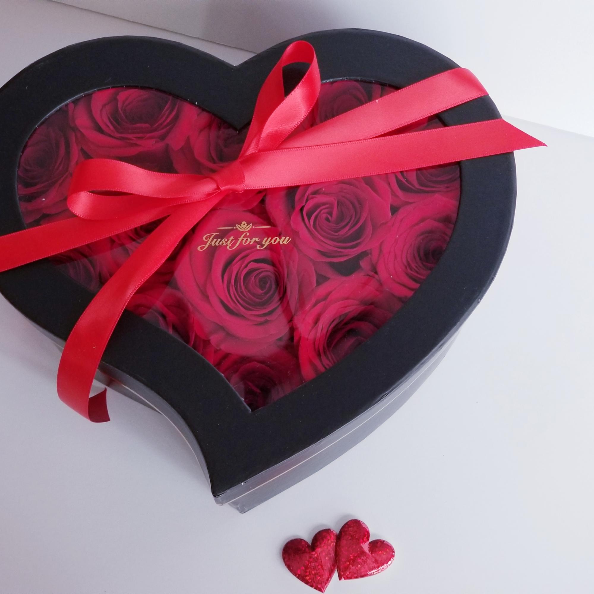 Heart-shaped box of red roses tied with a red ribbon