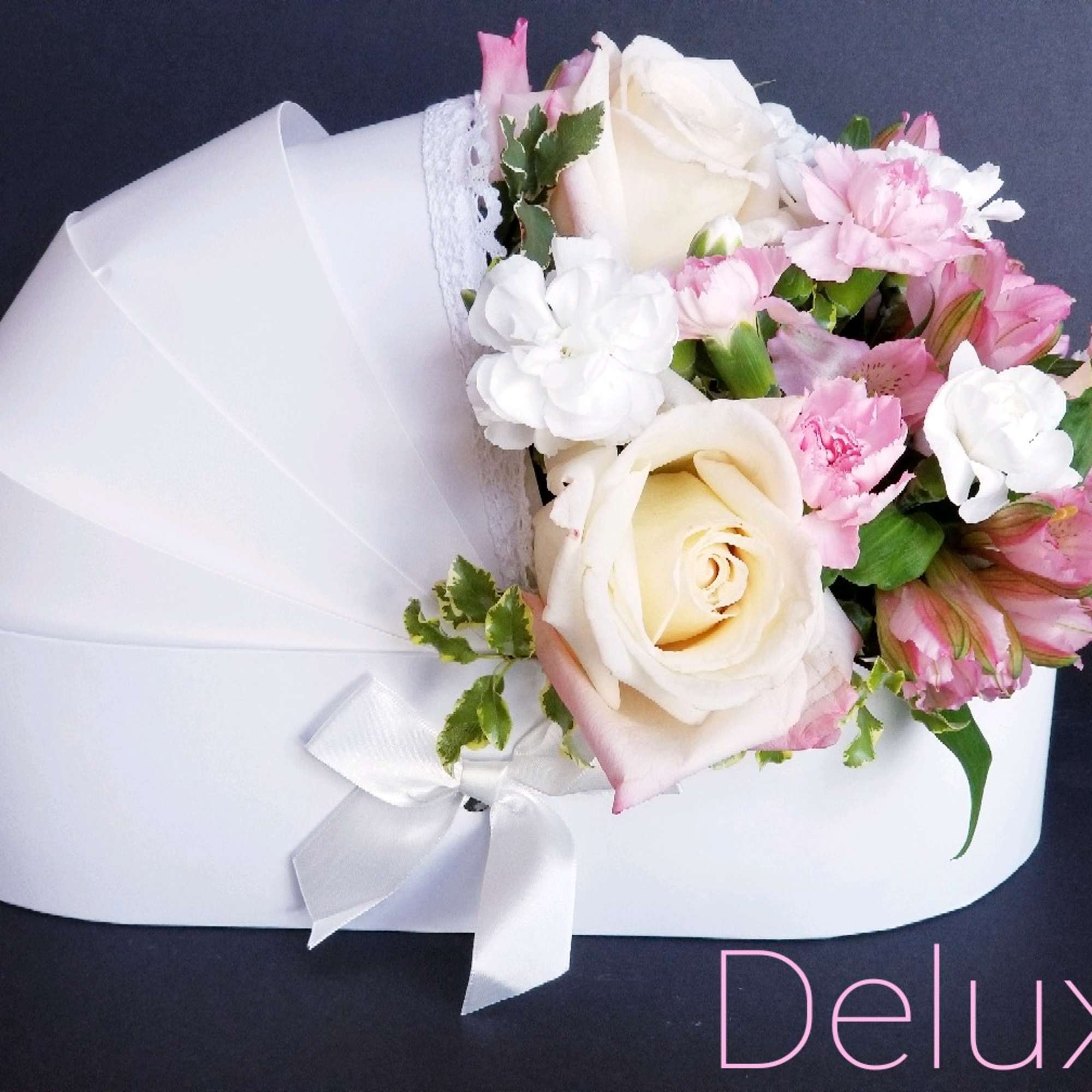 White and pink rose bouquet wrapped in white paper with a ribbon