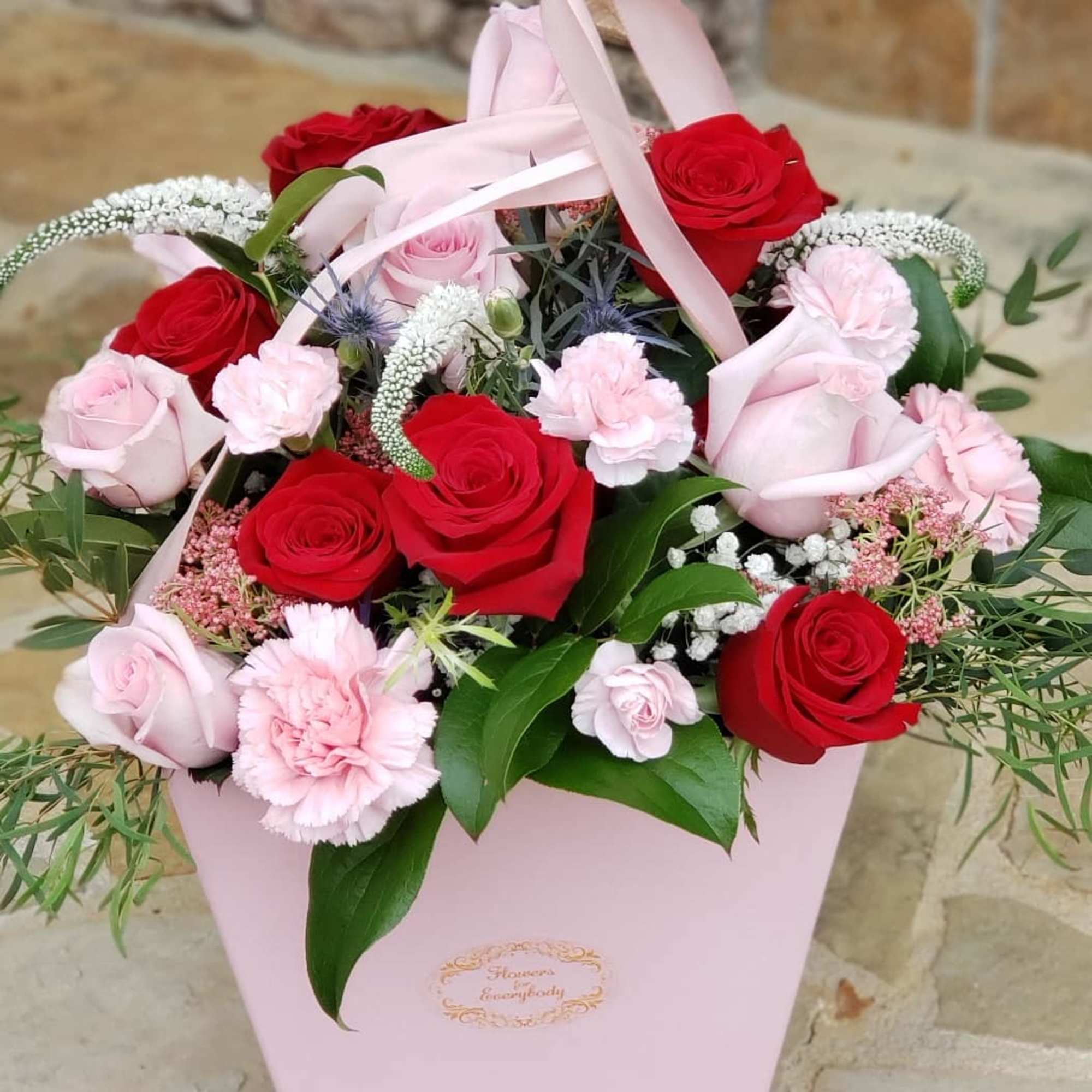 Pink box arrangement with red and blush roses and carnations