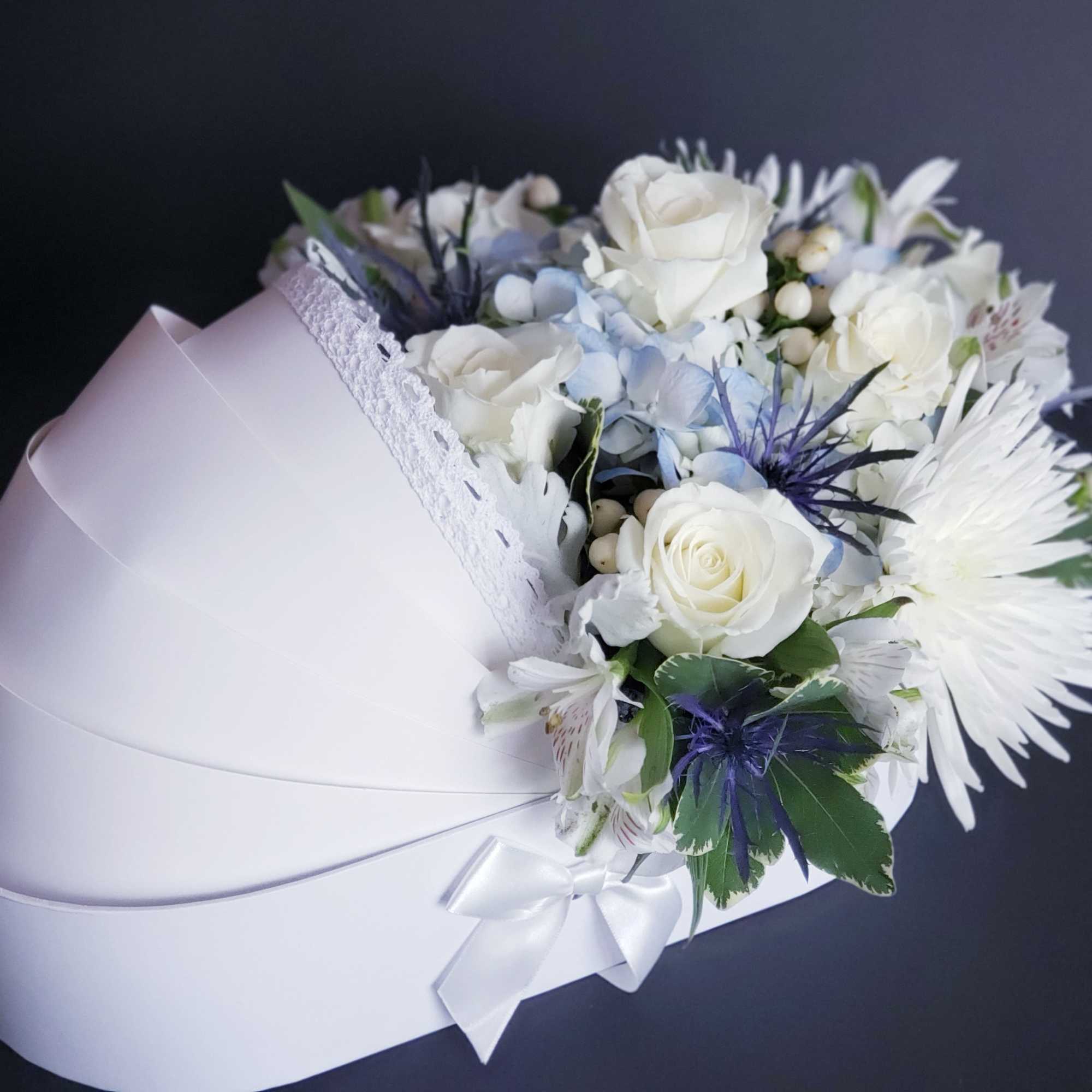 White rose bouquet with pale blue flowers in a white hat box