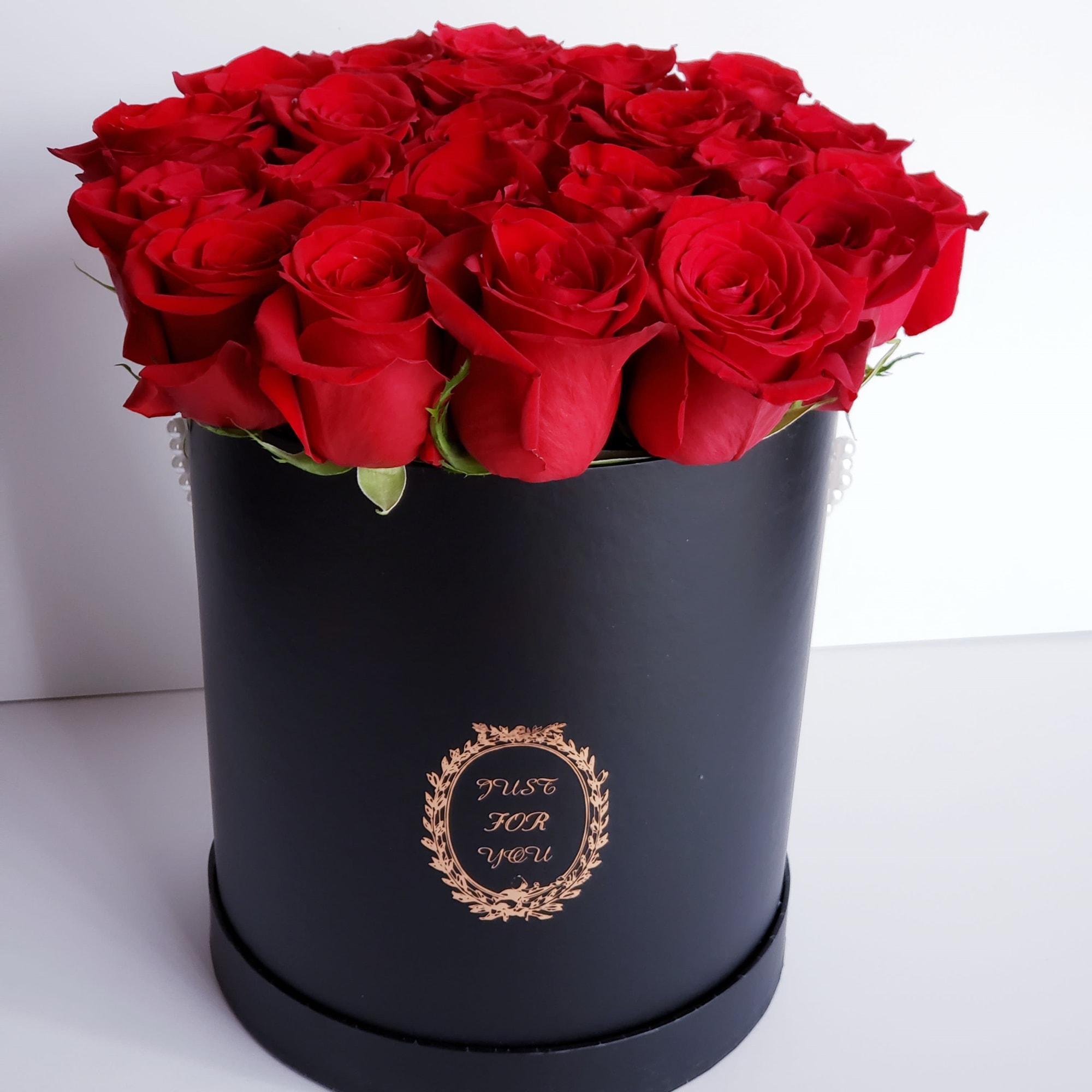 Red roses arranged in a black round box