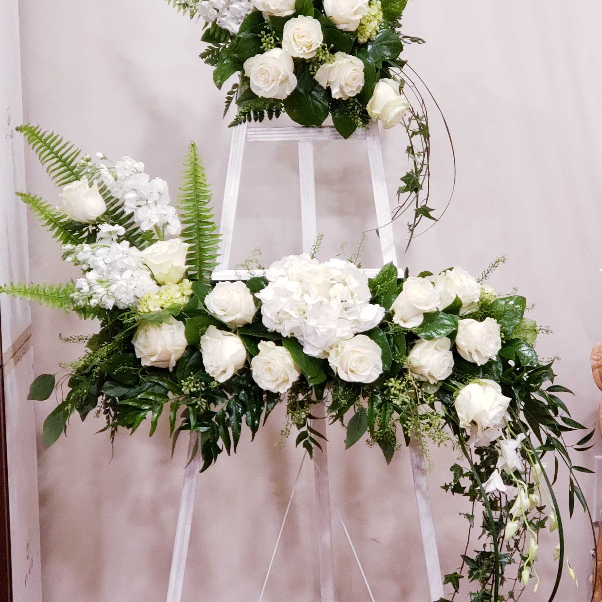 White rose and hydrangea floral display on a white easel