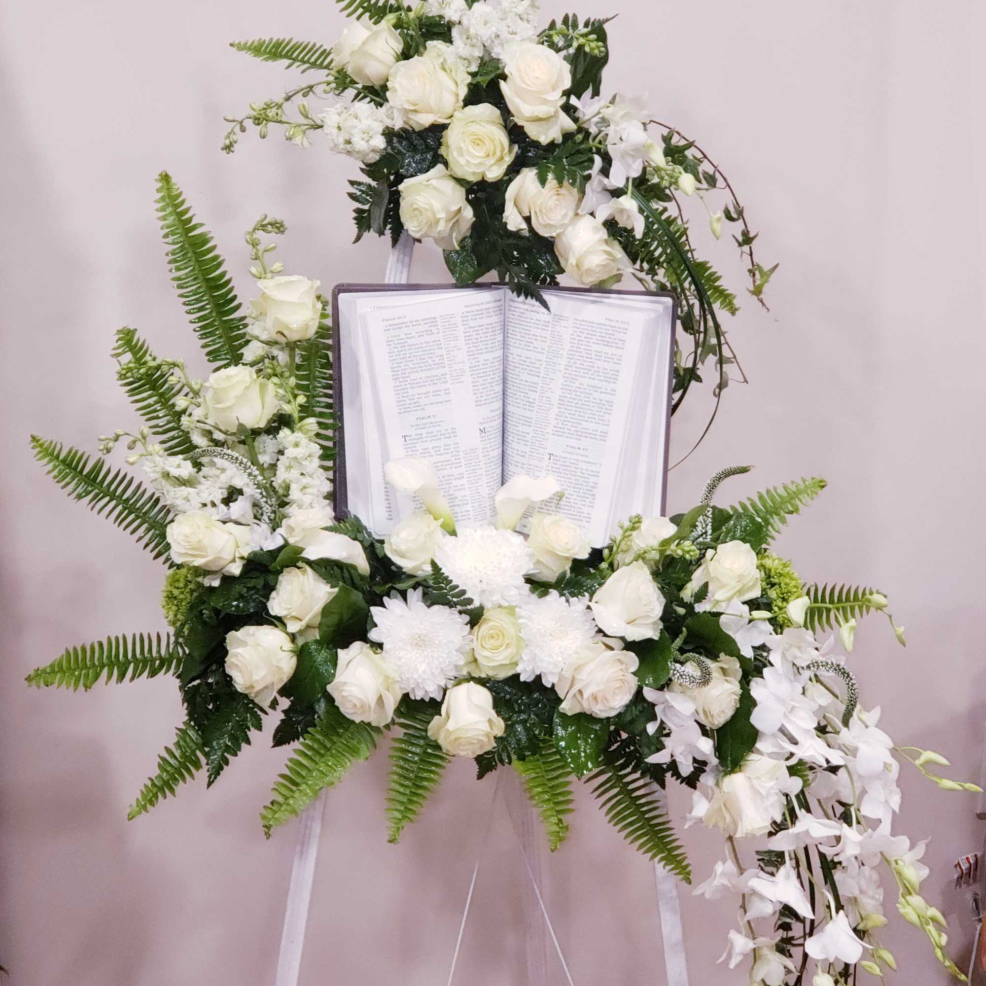 Beautiful white blooms easel spray with Bible. 