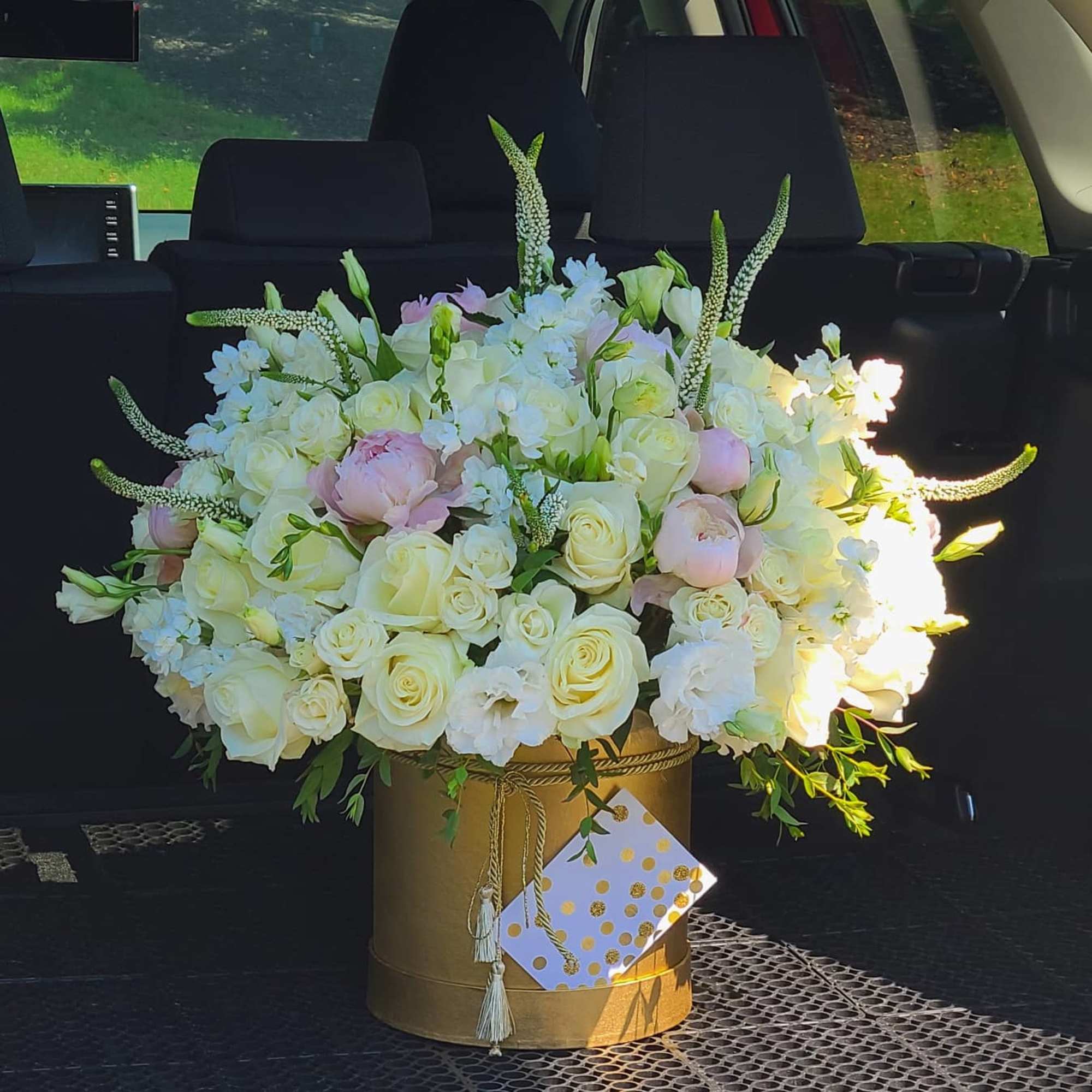 Large bouquet of white and pale pink flowers in a gold box