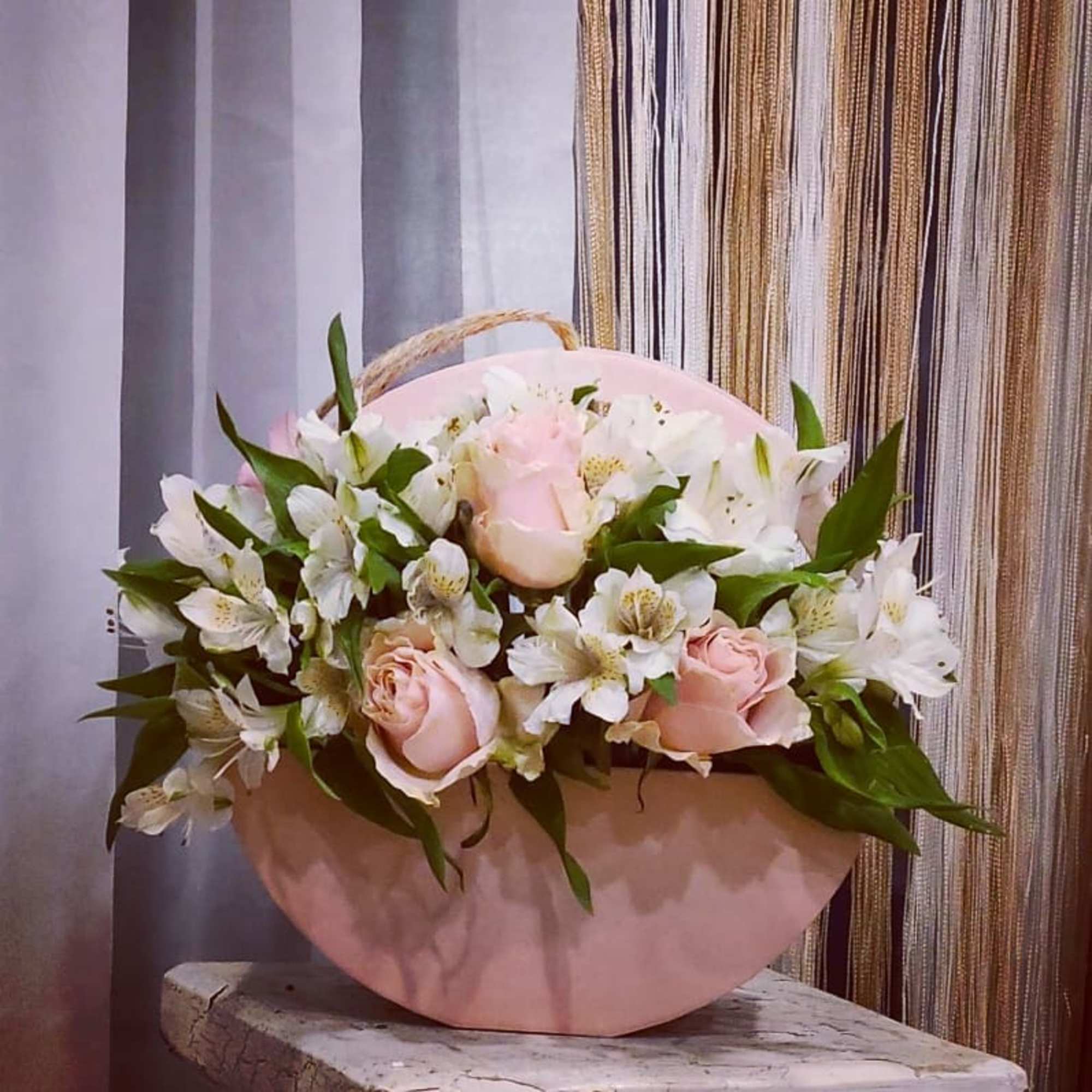 Pink roses and white alstroemeria in a round pink box
