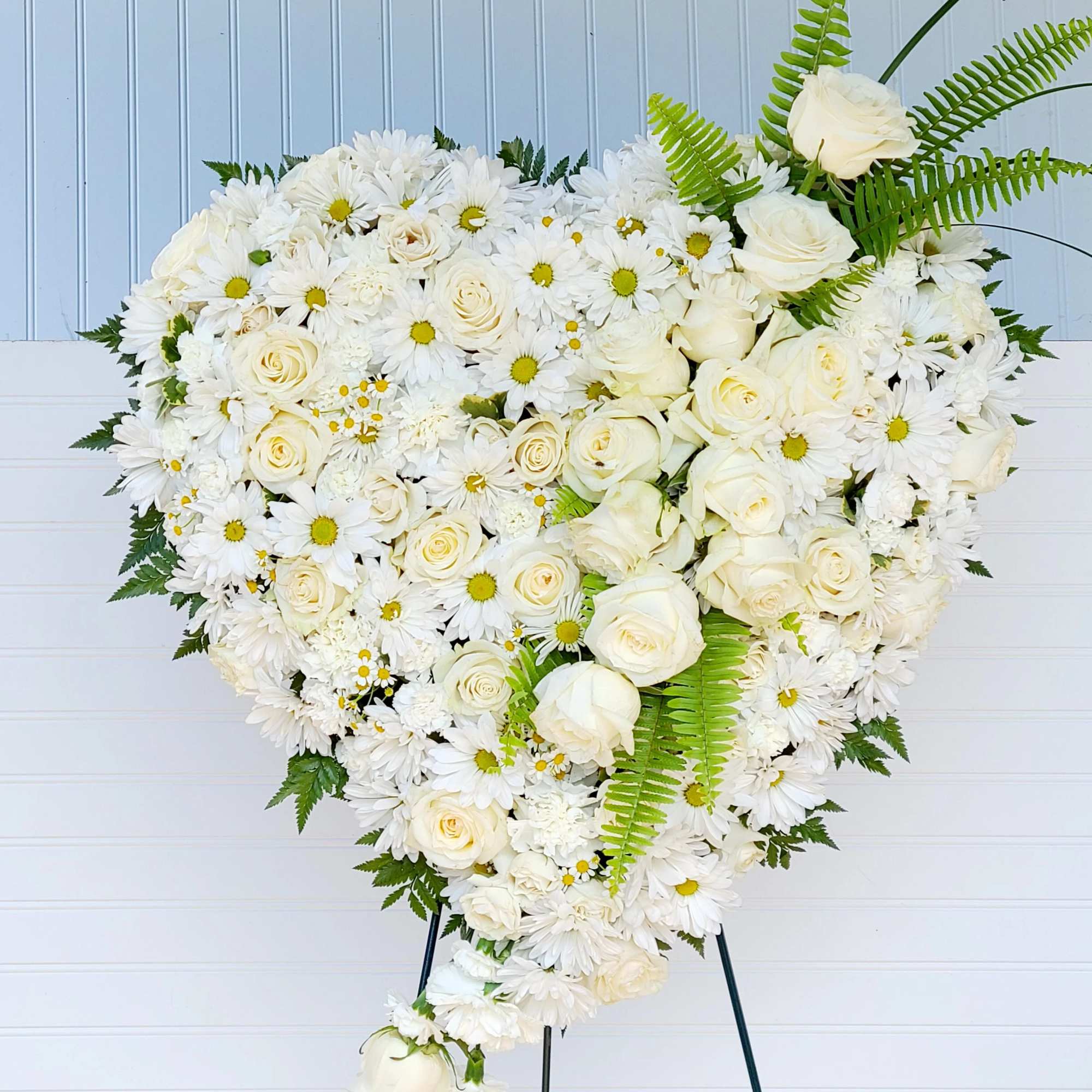 Heart-shaped white floral spray on a stand