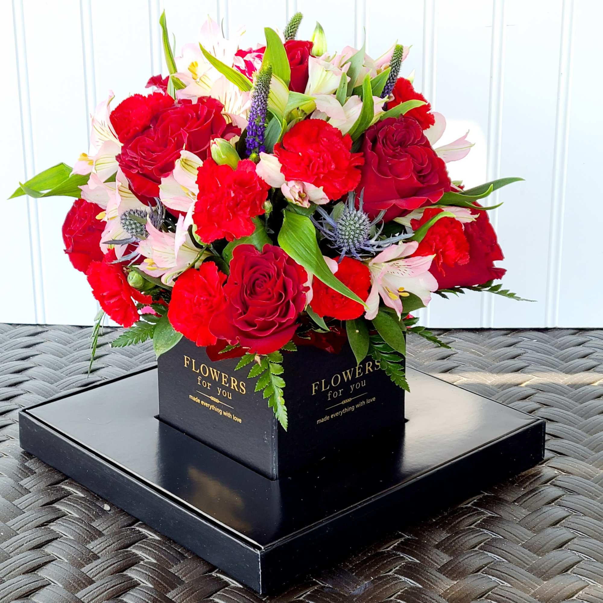 Red roses and carnations in a black box arrangement