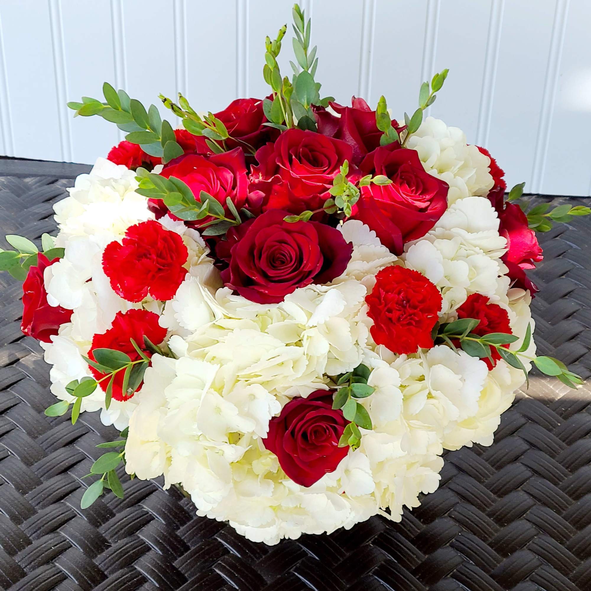 Red roses and white carnations arranged in a low bouquet
