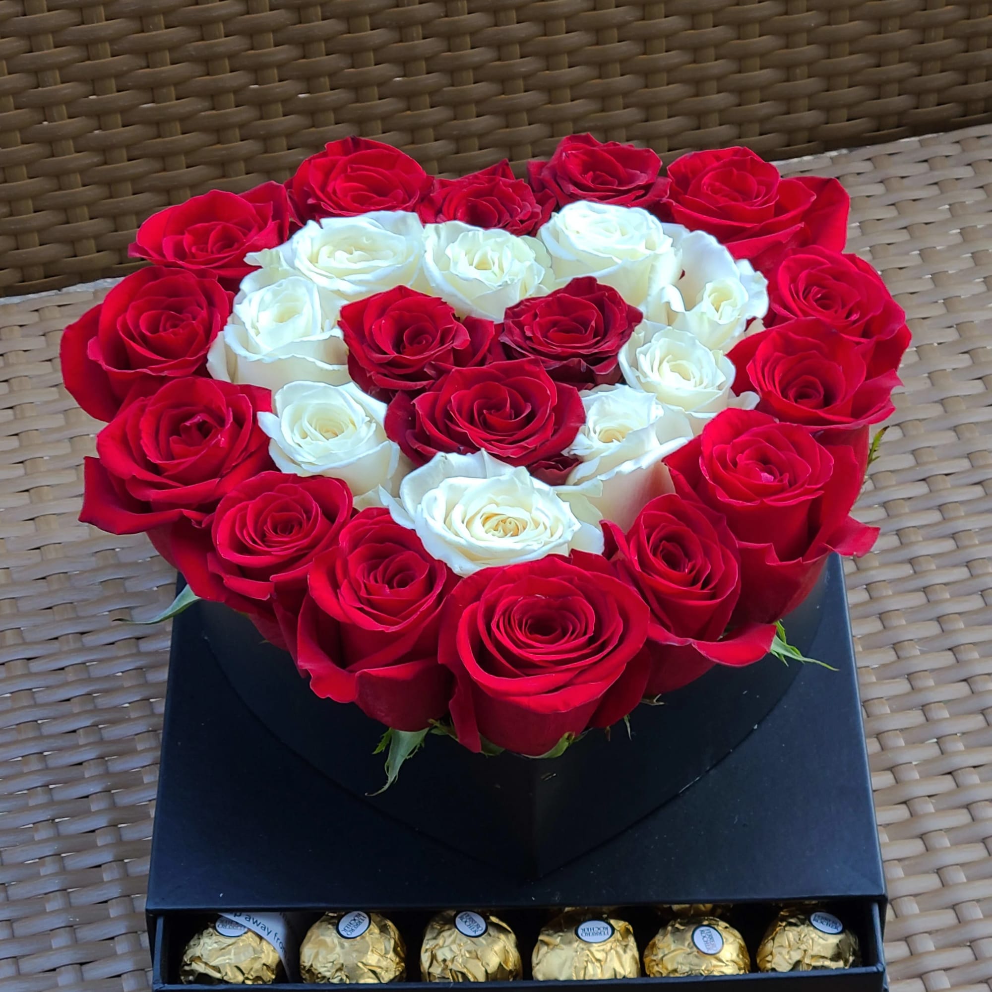 Heart-shaped box of red and white roses with chocolates in a drawer