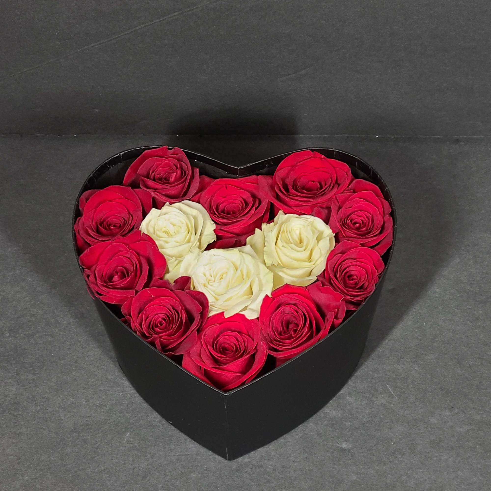 Heart-shaped box filled with red and white roses