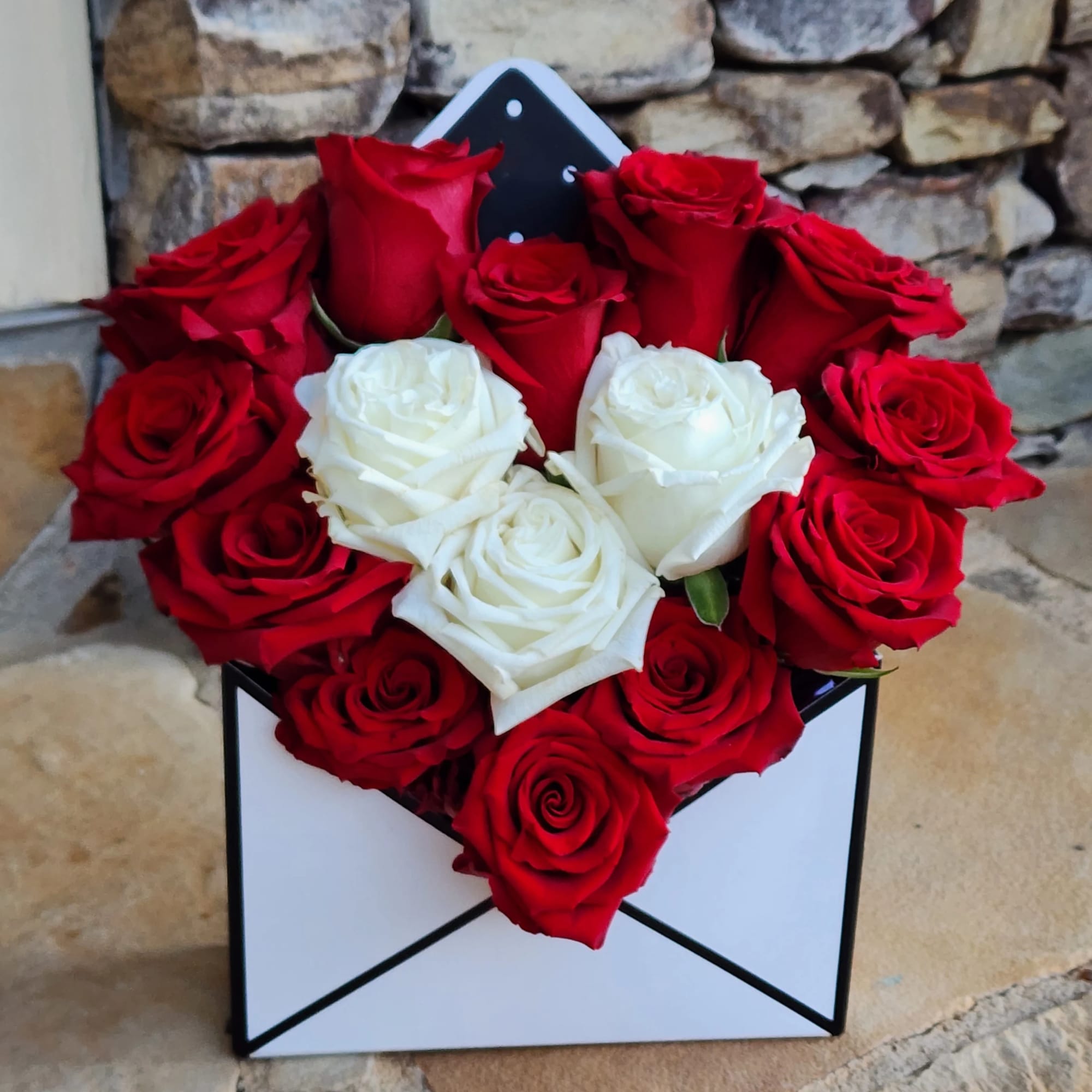 Red and white roses arranged in a black-and-white box