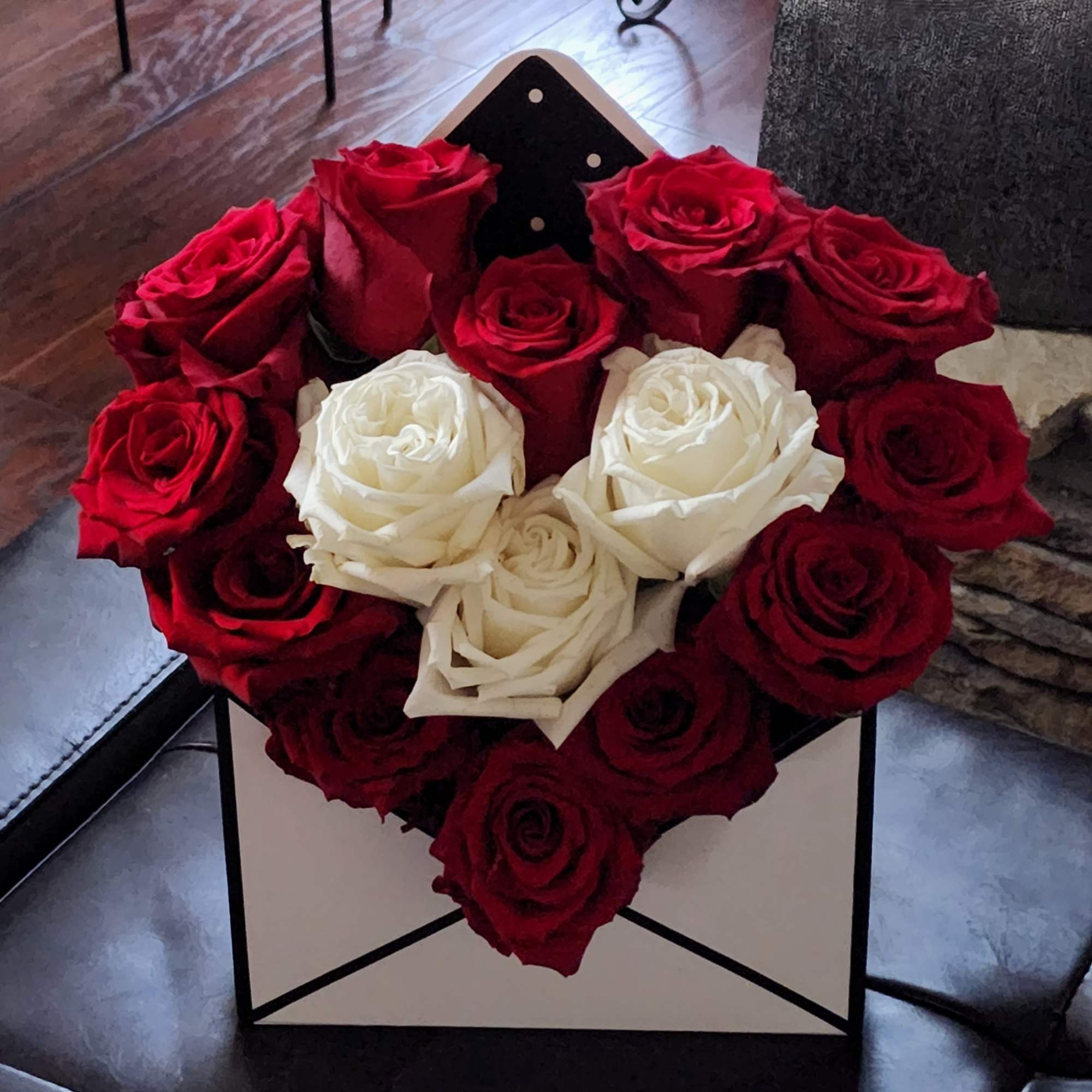 Heart-shaped bouquet of red and white roses in a gift box