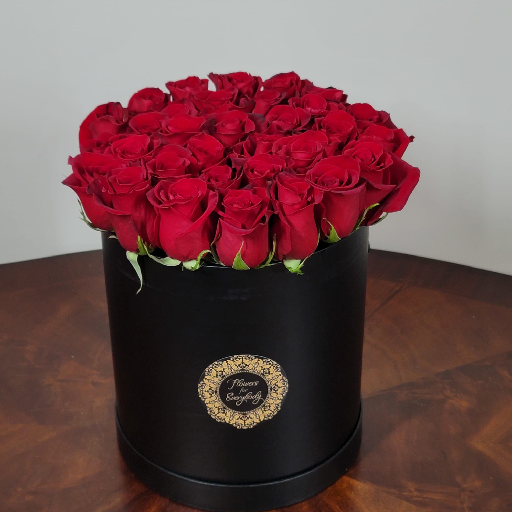 Red roses arranged in a black round box