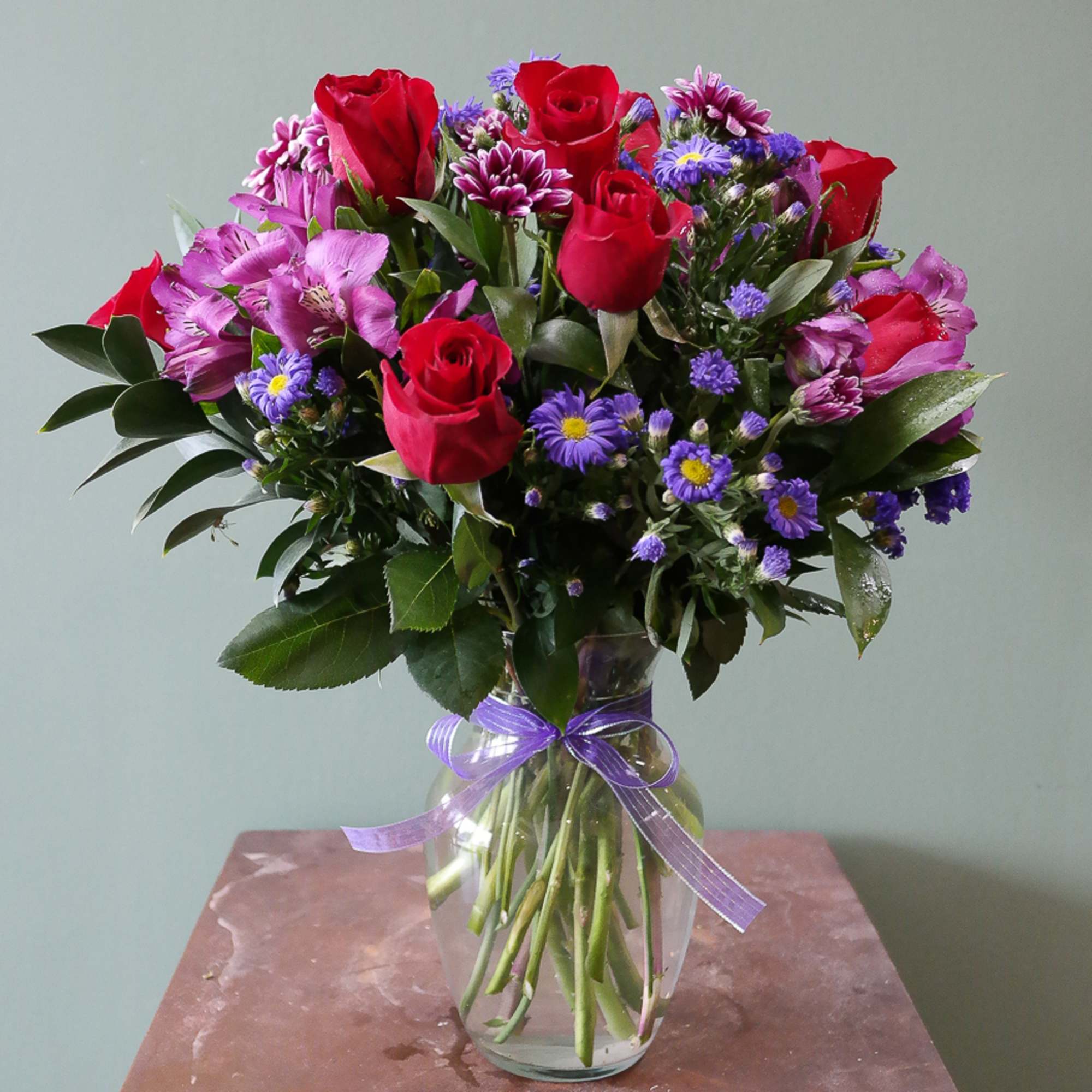 Red roses, purple monte casino, poms and alstroemeria. 