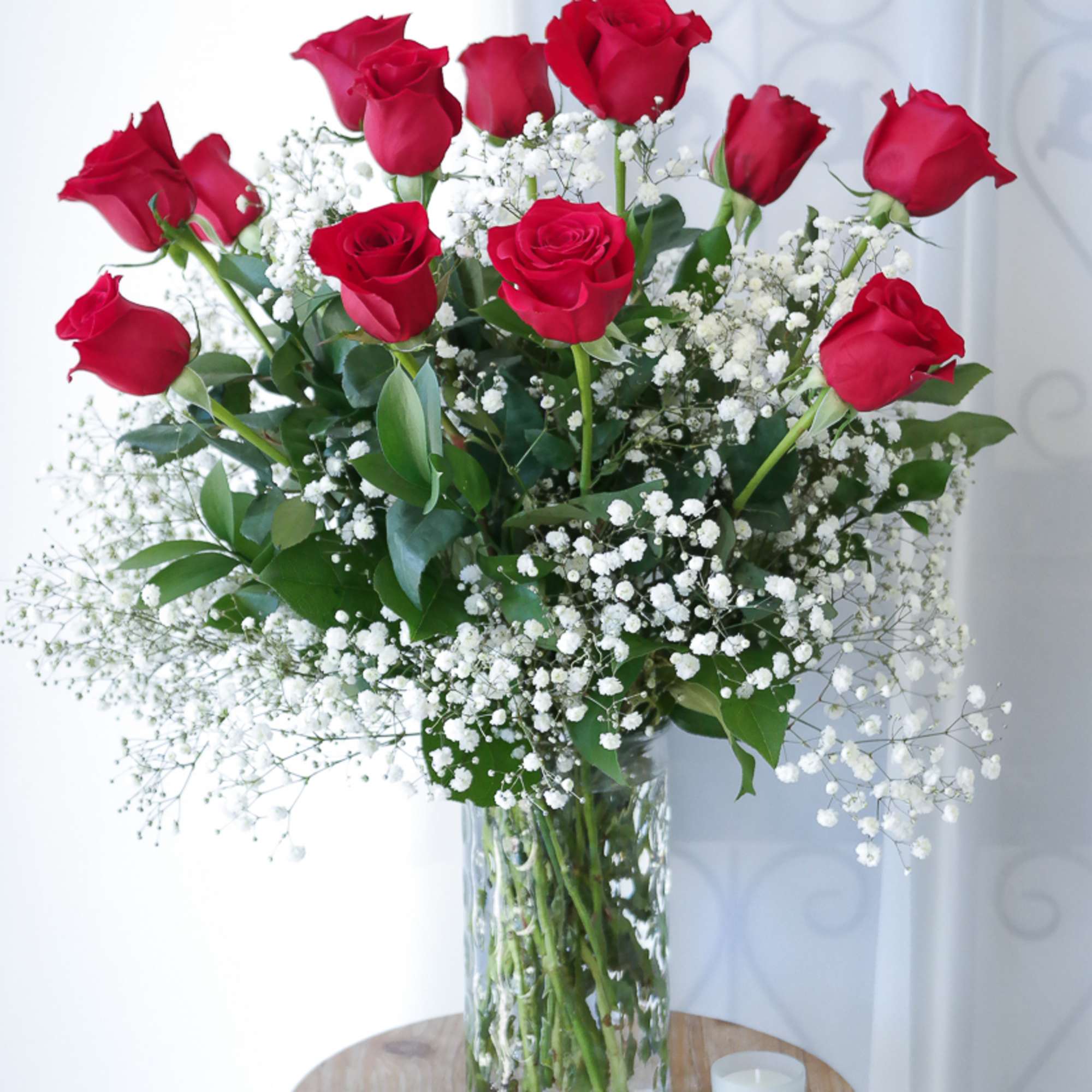 12 long stemmed red roses beautifully arranged with baby's breath. 
One of