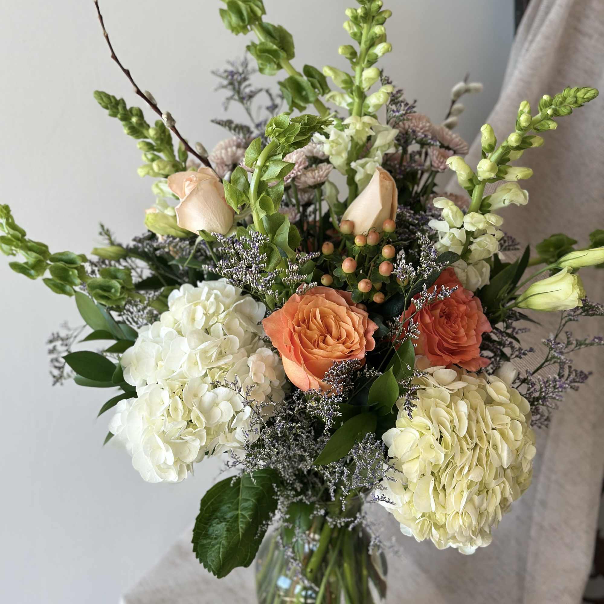 Peach-toned roses, white hydrangeas, lavender stock, hypericum - A blissful blend of
