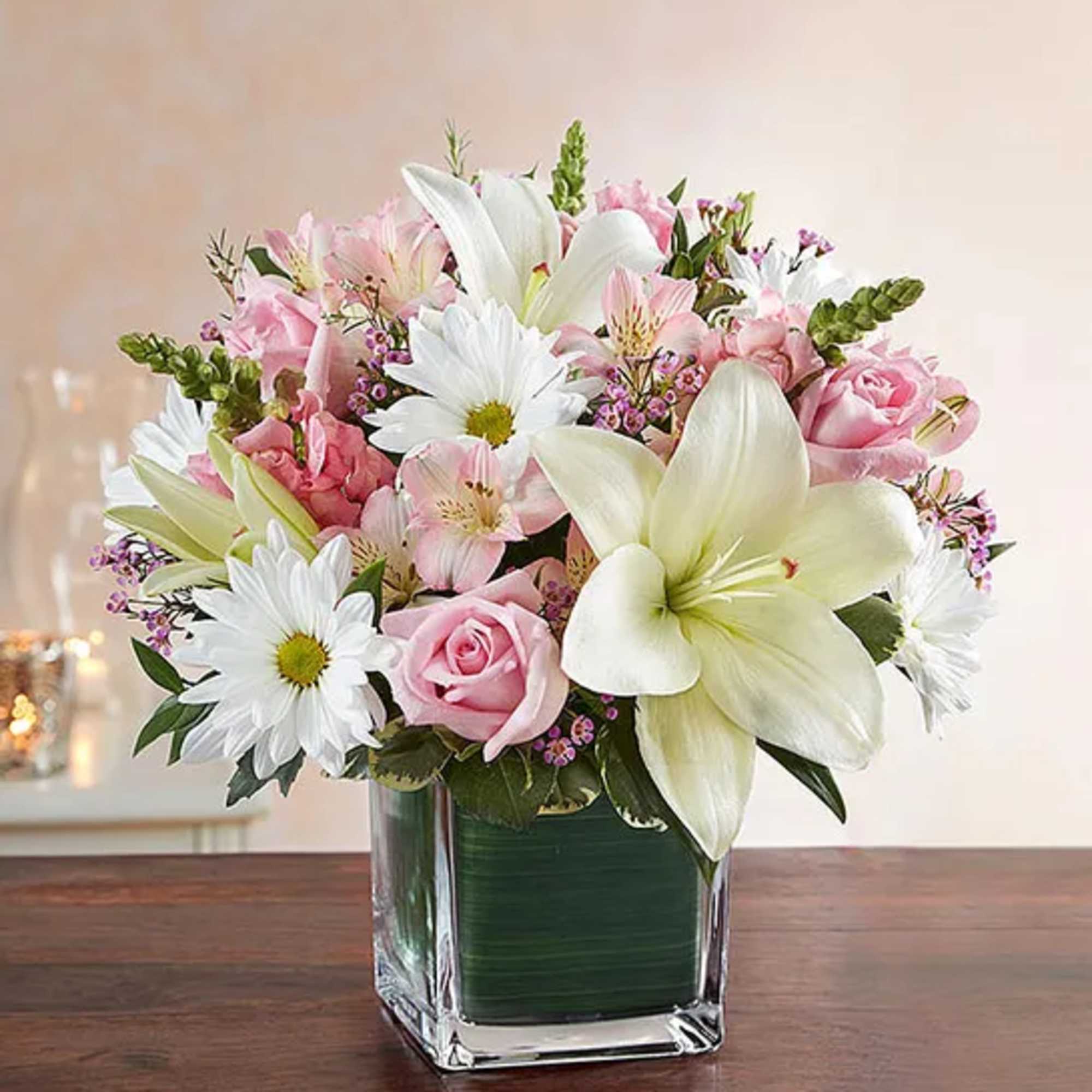 Pink and white bouquet in a clear square vase