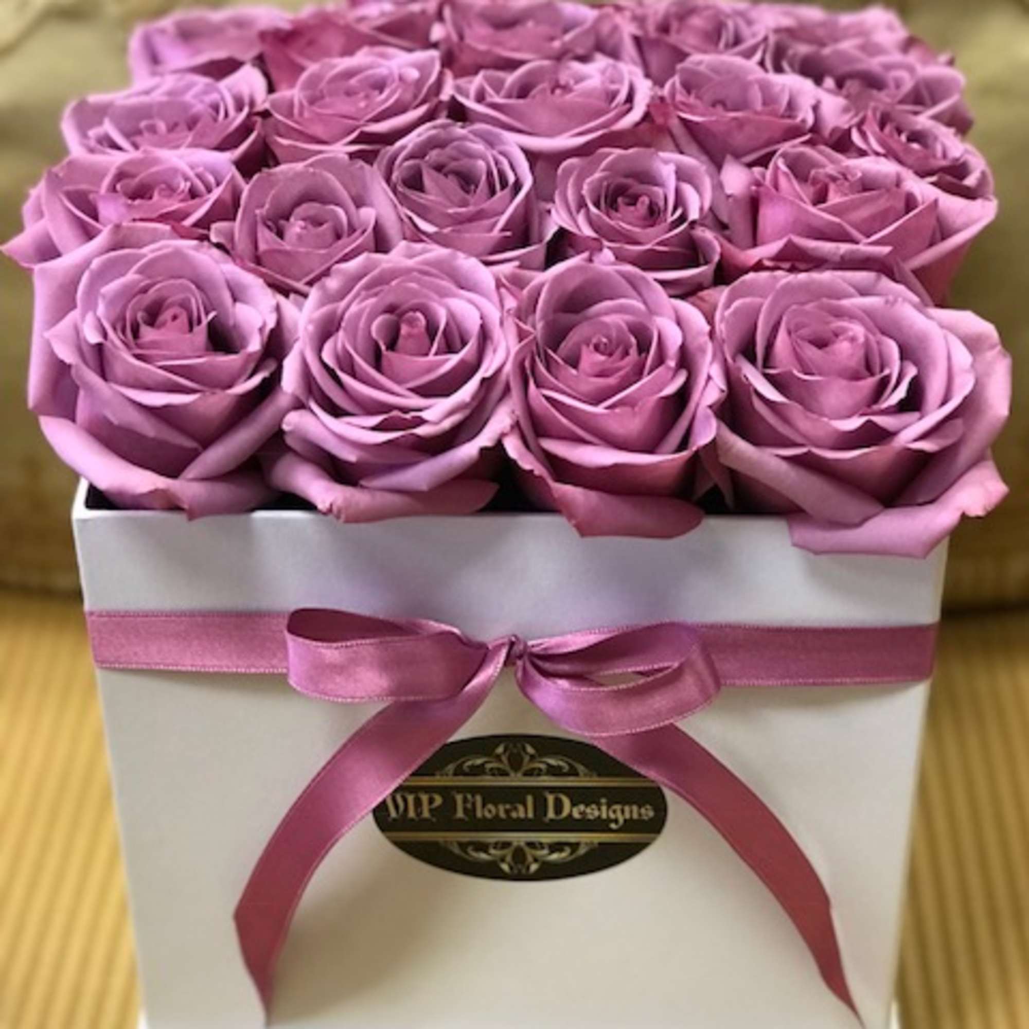 Box of lavender roses tied with a pink ribbon