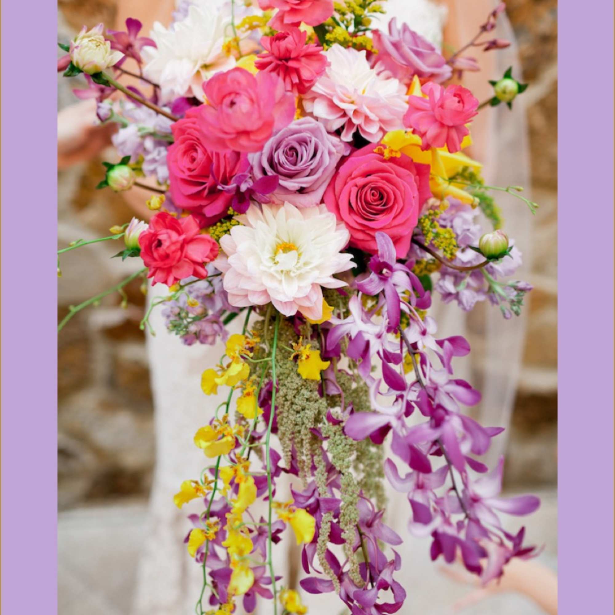 Cascade bouquet of pink, white, and purple flowers with trailing orchids