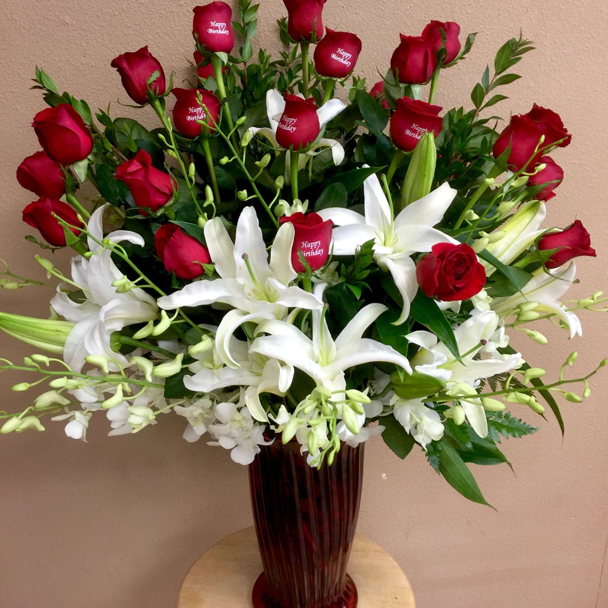Red roses and white lilies in a tall red vase